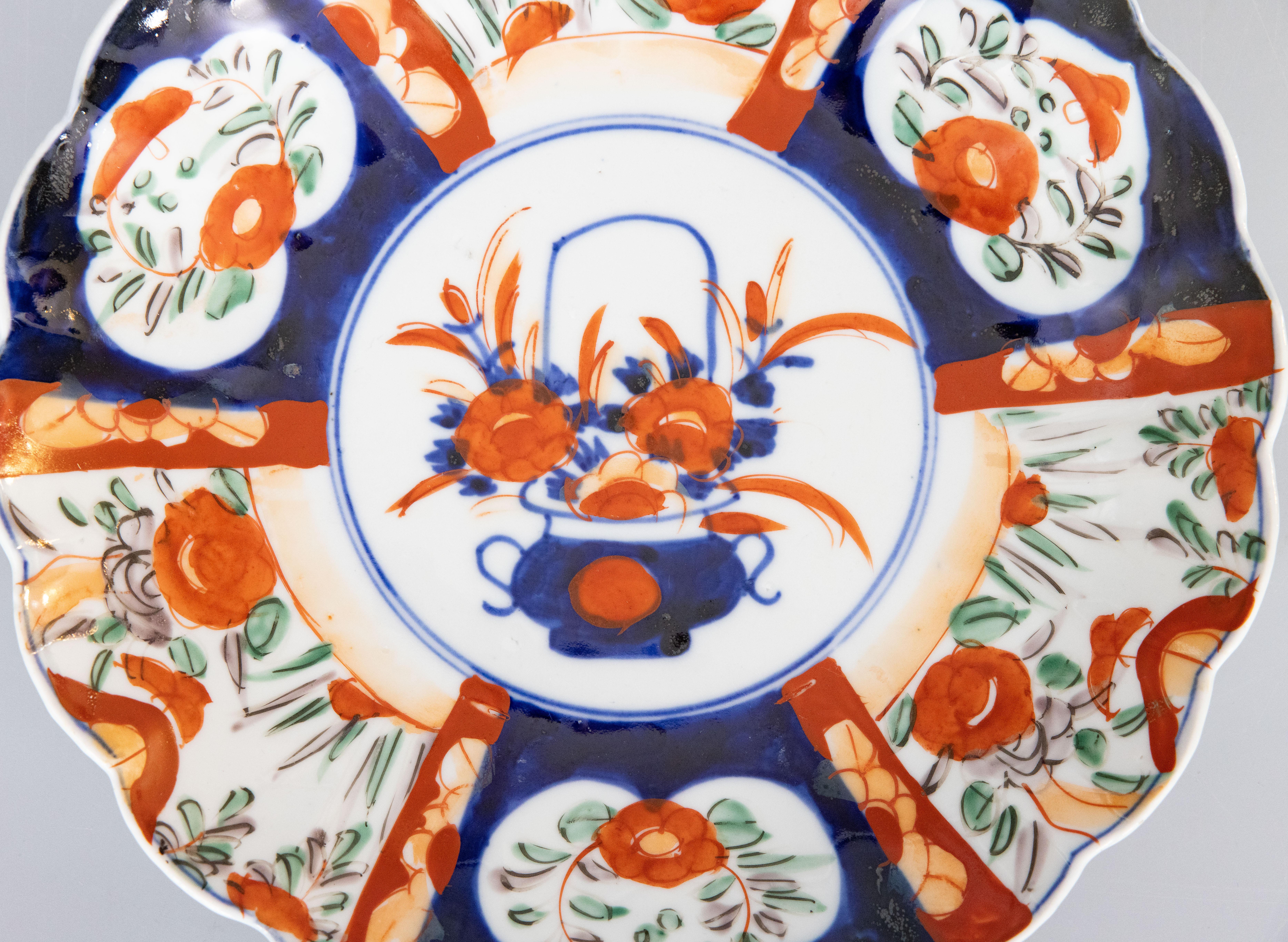 A gorgeous 19th-Century Japanese Meiji Period Imari porcelain charger with a hand painted floral design in the traditional Imari colors. This fine large plate has lovely scalloped edges and is quite heavy, weighing over 2 lbs. It displays