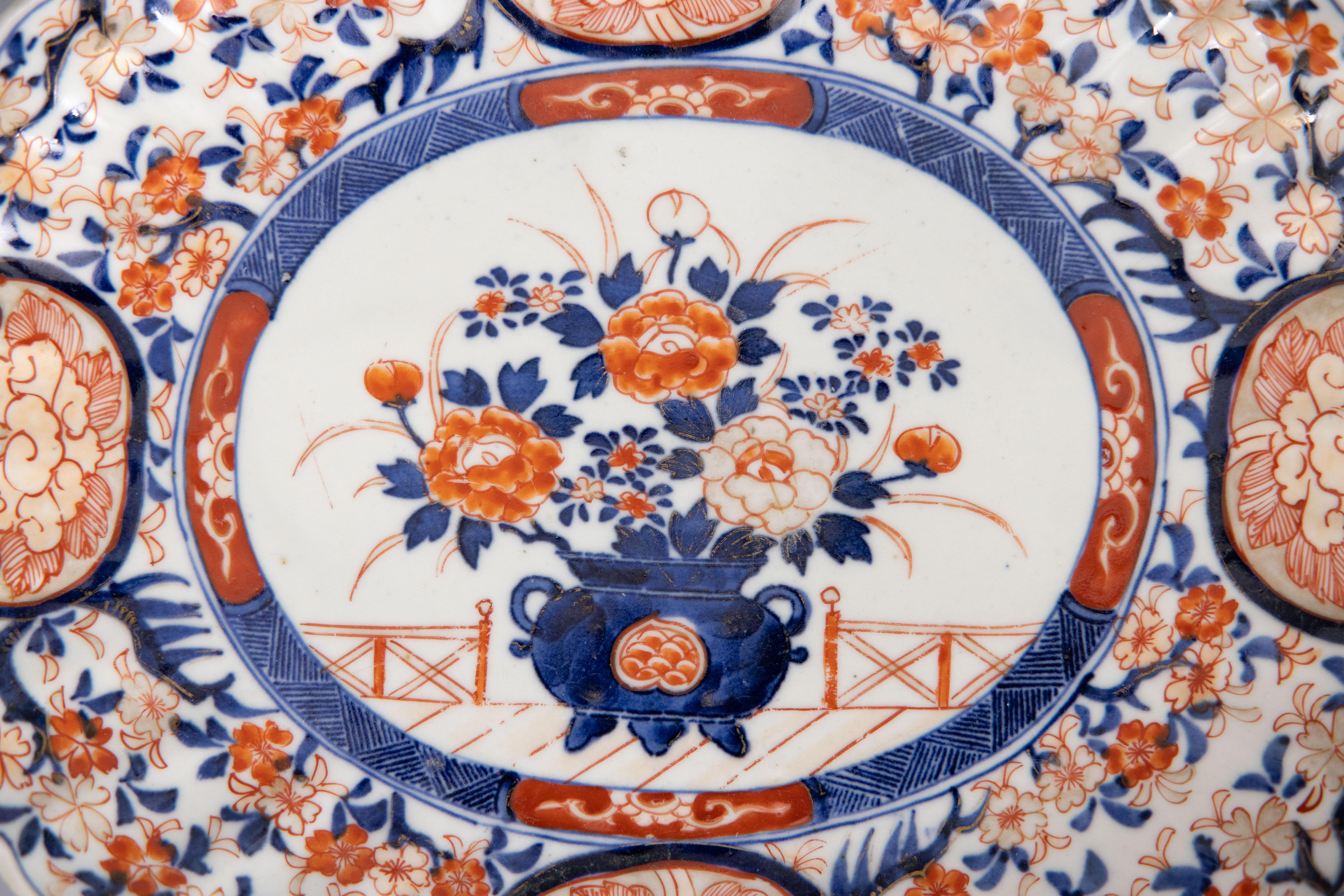 Magnifique assiette ou plateau ovale en porcelaine japonaise de la période Meiji, datant du 19e siècle, avec des motifs floraux peints à la main dans les couleurs traditionnelles d'Imari. Ce plat fin a de jolis bords festonnés et se présente