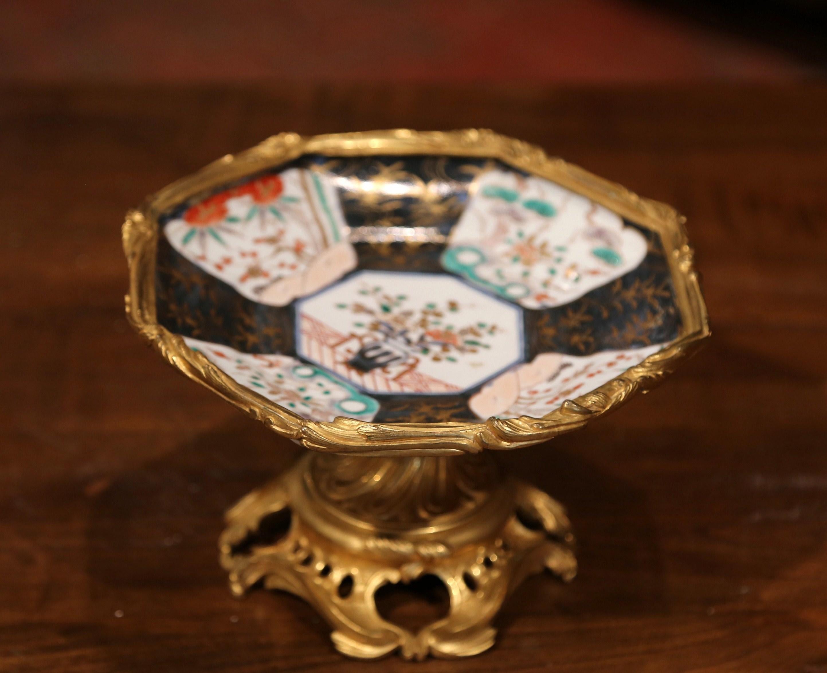 Place this antique Imari bowl on your entry buffet for a small dose of oriental design. Crafted in Japan, circa 1860, and circular in shape, the exotic porcelain vide poche sits on an ornate Louis XV gilt bronze stand. The shallow, ceramic bowl