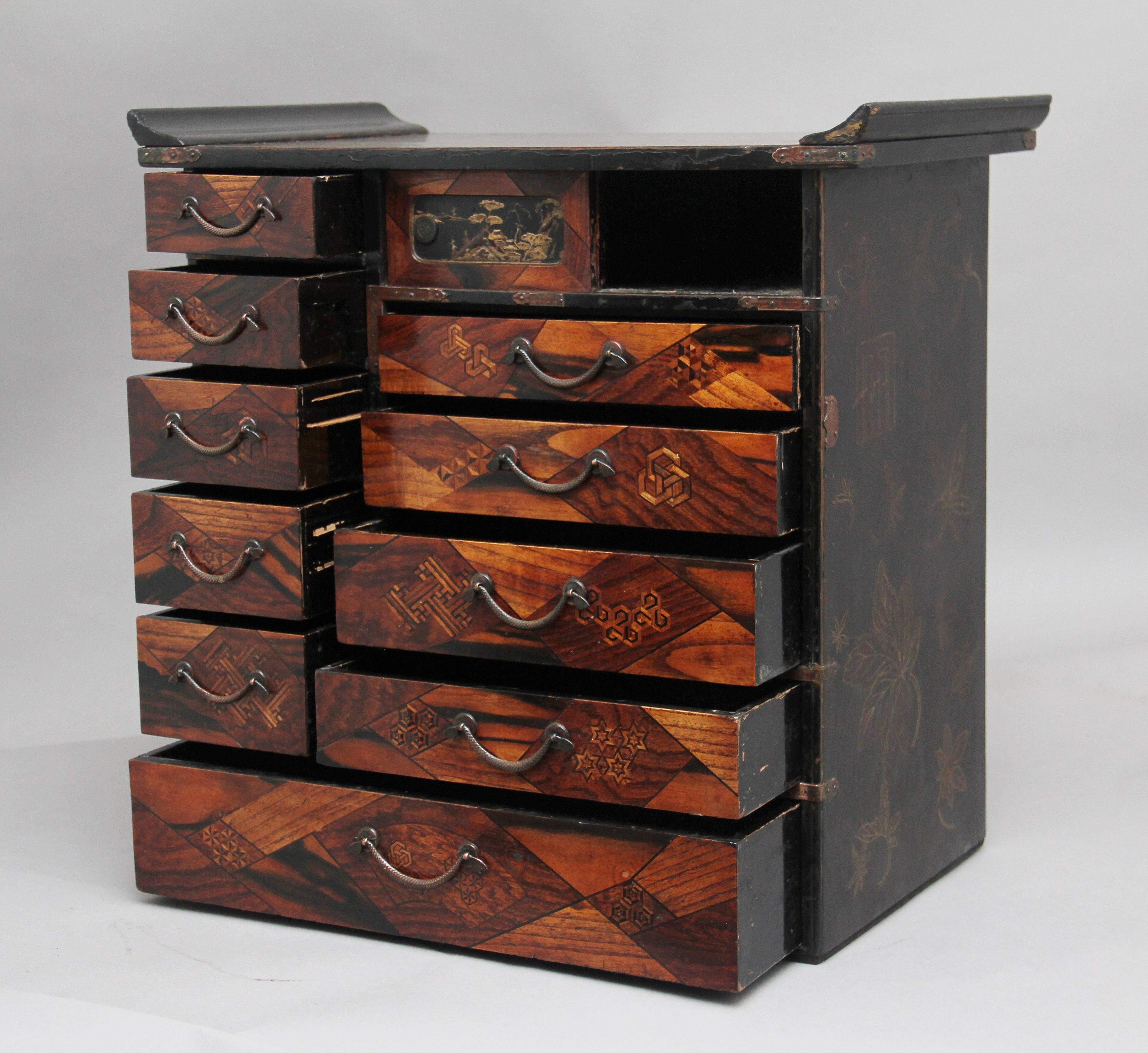 19th century Japanese parquetry and lacquered cabinet from the Meiji period, the top, sides and back lacquered with floral decoration, the front of the cabinet consisting of ten various size drawers, the parquetry on the drawer fronts is