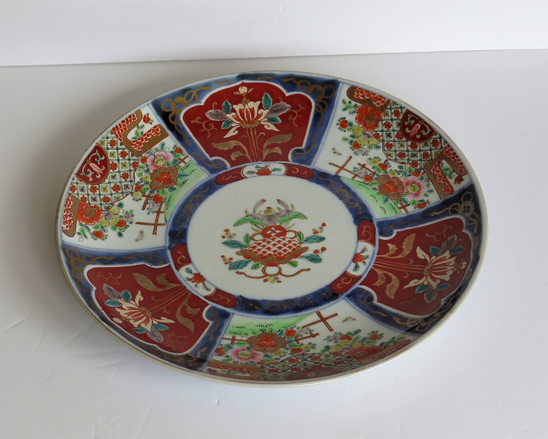 This is a good quality, hand decorated Japanese porcelain charger, large plate or bowl with an Imari pattern, dating to the late 19th century, Meiji period, circa 1880.

The circular charger is well potted on a low foot.

It is hand decorated in