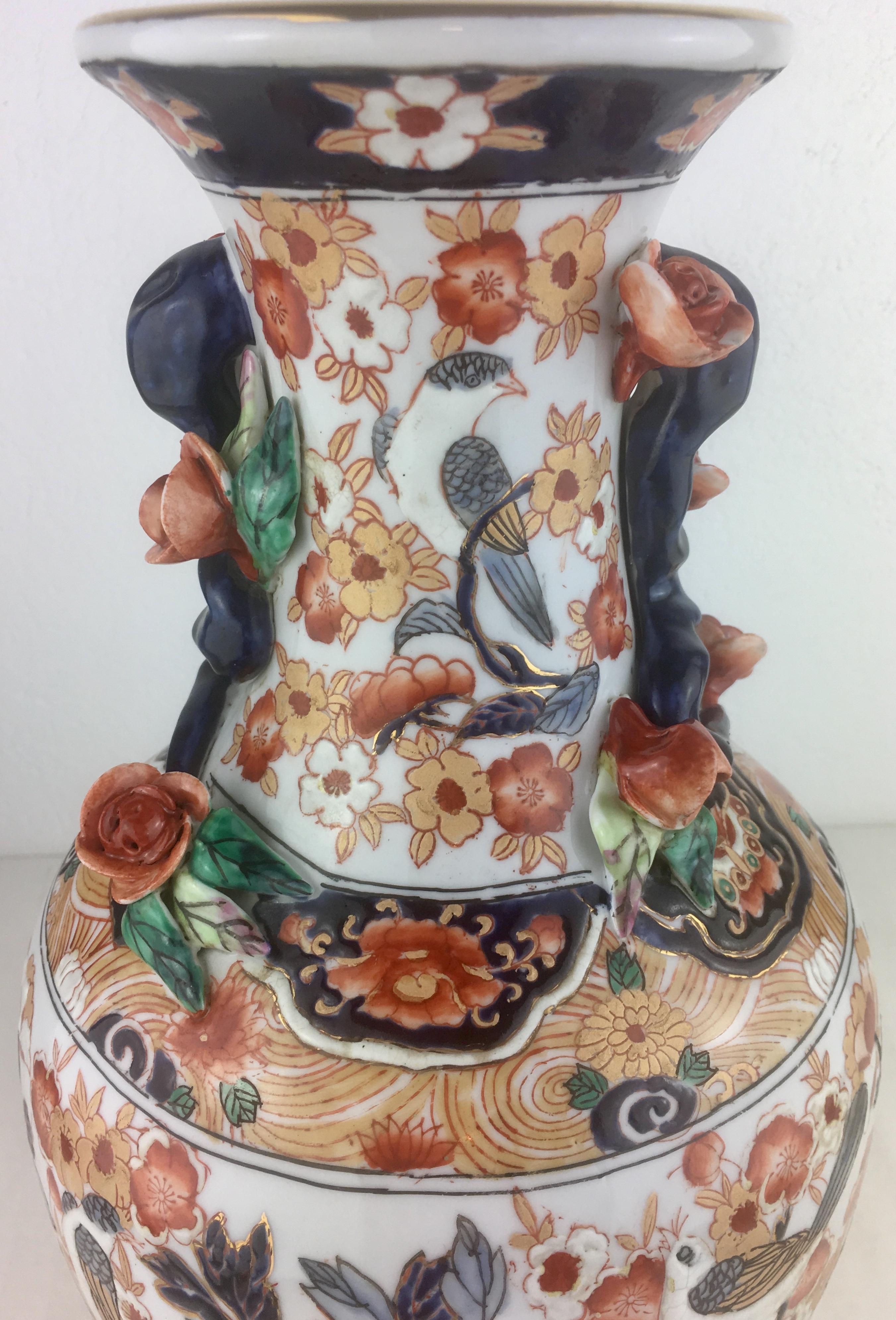 Decorate a mantel or a buffet with this colorful antique Imari vase; hand-crafted in Japan. This elegant 19th century porcelain vase features hand-painted decor of birds, flowers, leaves and butterflies in the blue, green, orange, blue and gold