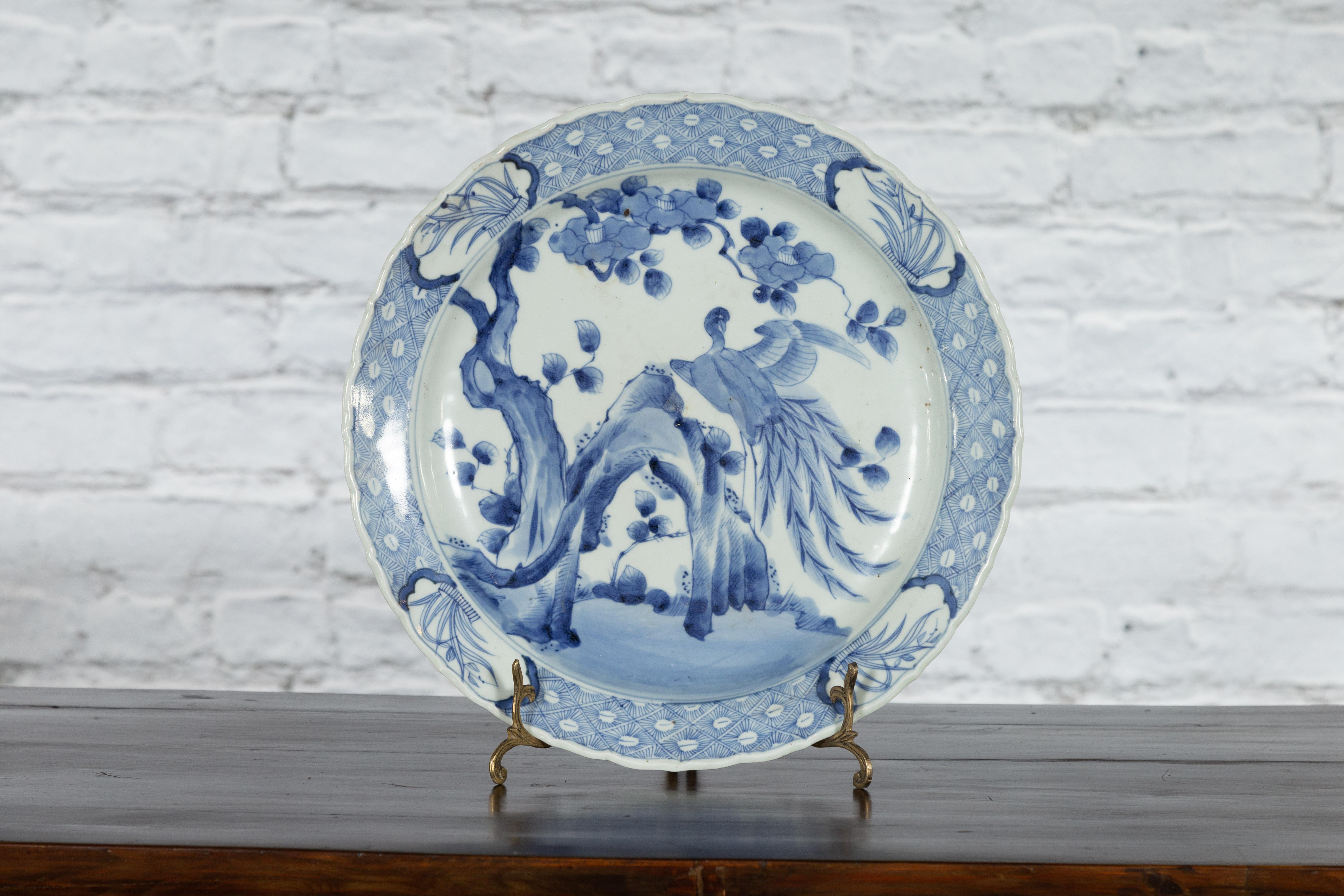 Ein japanischer Porzellanteller aus dem 19. Jahrhundert mit handgemaltem blau-weißem Baum-, Fels- und Vogeldekor. Dieser Porzellanteller, der im 19. Jahrhundert in Japan hergestellt wurde, zeigt ein zartes blau-weißes Dekor, das ein kunstvolles,