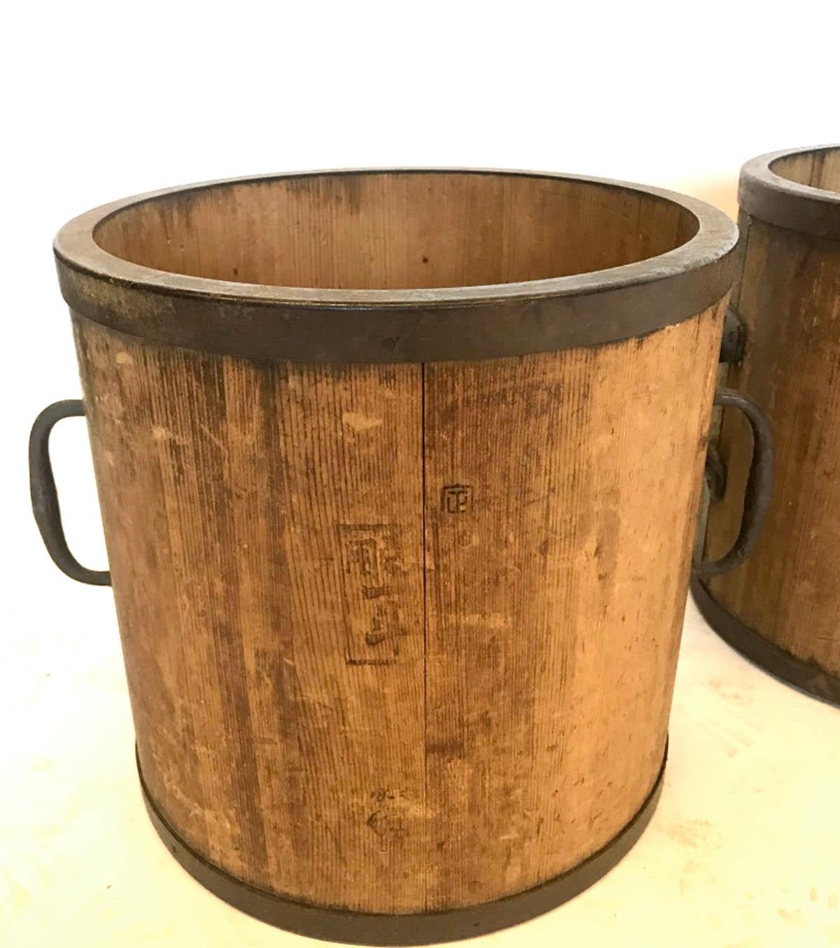 19th century wooden buckets rimmed in iron which contained rice. Beautiful patina. Functional, great as planters.
