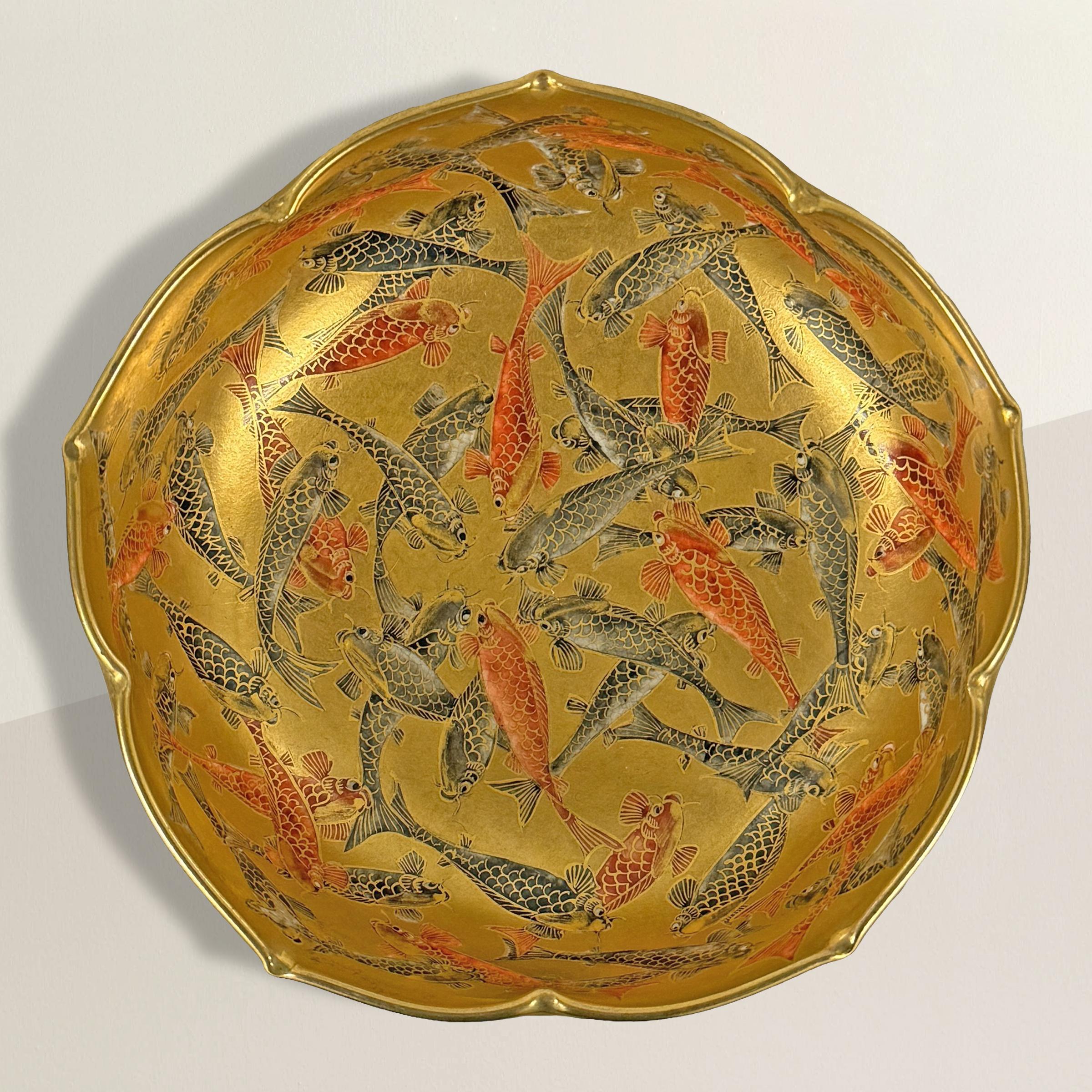 This extraordinary 19th-century Meiji period Japanese Satsuma lotus-form bowl is an epitome of artistic mastery and cultural significance. Adorned meticulously with red and black koi gracefully traversing a shimmering pond of gilt porcelain, it