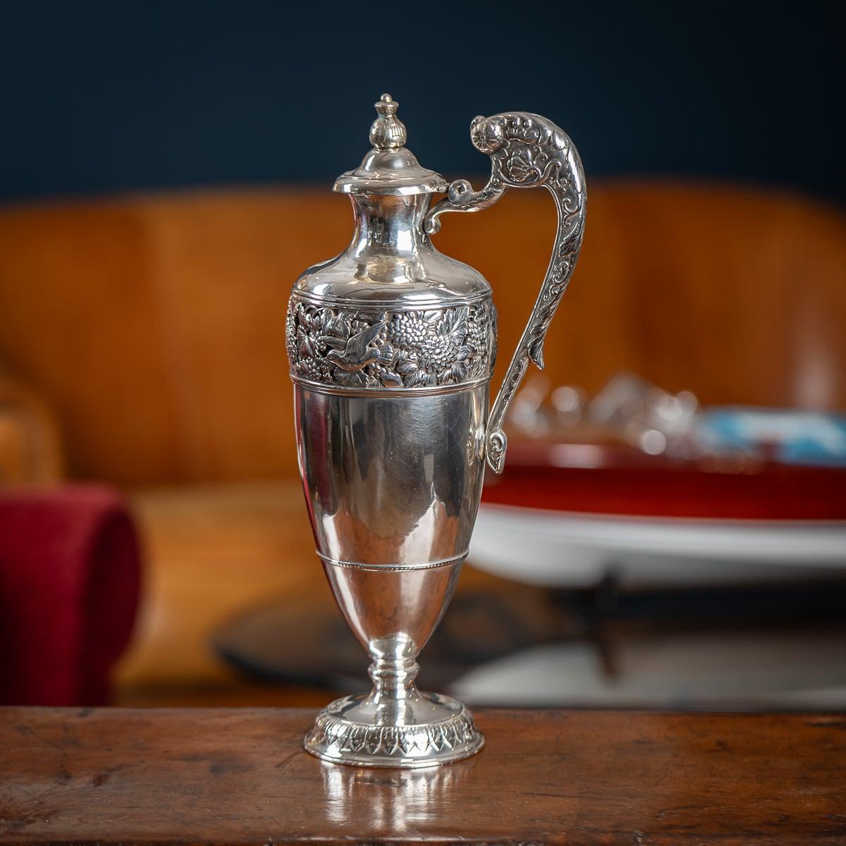 Antique late 19th century Japanese Meiji period solid silver wine jug, simply exceptional and magnificent quality, The lidded wine jug is of classical shape, mounted with a finely decorated finial and unusual scroll handle and applied with a pierced