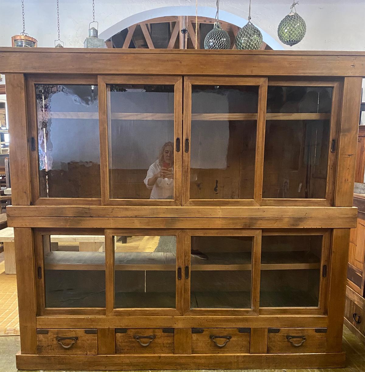 Handsome Japanese 19th century sliding glass door display cabinet in two pieces. Top portion is all display with one interior shelf. Bottom portion is display with one shelf and four drawers below. In very good condition with original glass, wood