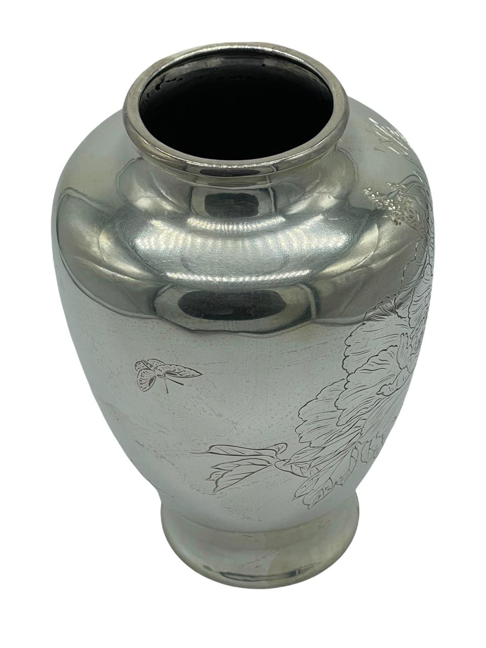 19th Century Japanese sterling silver vase with finely carved and embossed chrysanthemum flowers and butterfly. It has its maker’s mark on the bottom.

