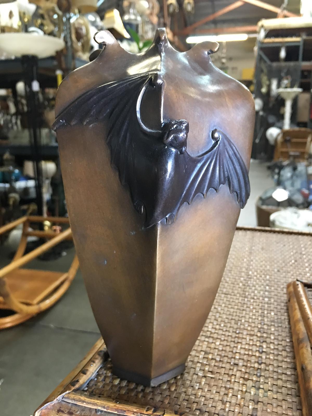 Casting from an original antique Japanese vase that was made in 1890 this solid bronze vase is finished in an antique patina. The six-sided, tapered design with rolled tips at the opening features a bat spreads across two sides with an Art Nouveau