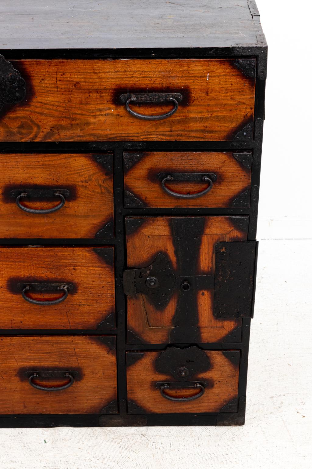 Japanese Tonsu chest of drawers in dark stained pine with elm drawer fronts and iron hardware, circa 19th century. Made in Japan. Please note of wear consistent with age including original patina due to antique age on the wood and metal along with