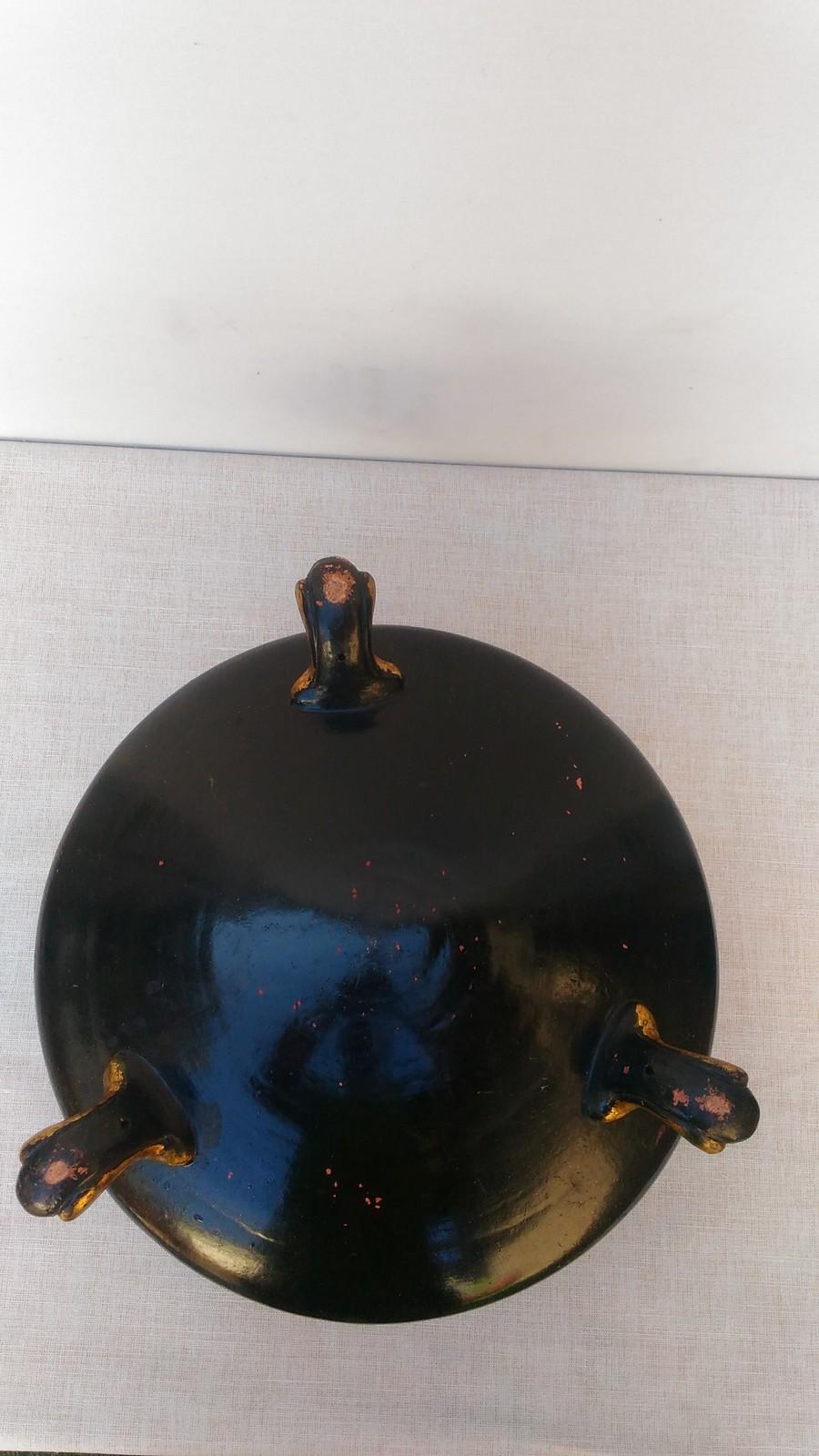 This pot cover in lacquered biscuit with an original zing inside is close to the works produced by the Faïencerie of Toul-Bellevue. It is circular in shape and rests on three legs. The paunch of the vase is black. All around, Asian reference