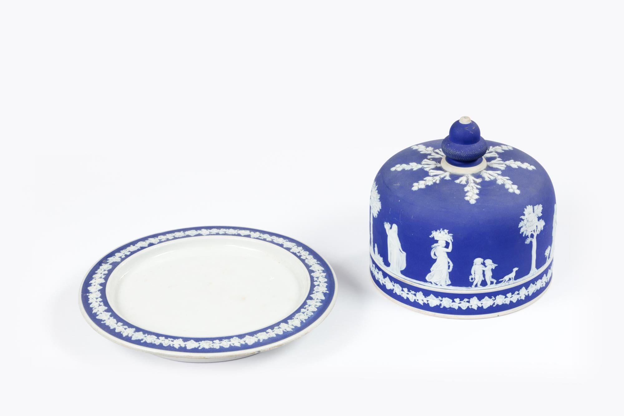 Schwere kobaltblaue Wedgewood Käseplatte aus Jasperware mit Kuppel.

Das aufgetragene weiße Flachrelief zeigt klassische figürliche Szenen mit Blattmotiven auf dem charakteristischen 