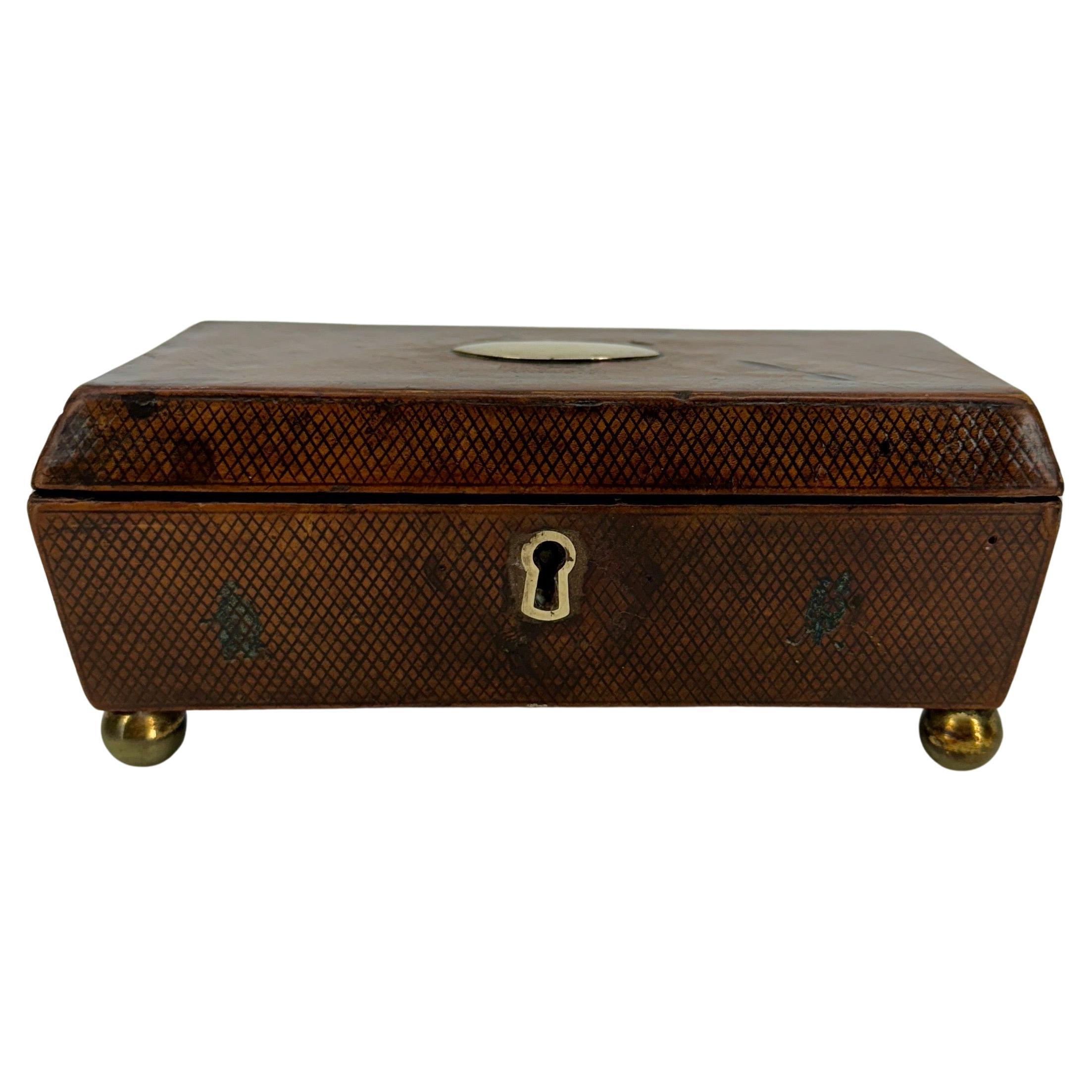 Small Rectangular Leather Jewelry Box on small brass balls with diamond pattern.  

