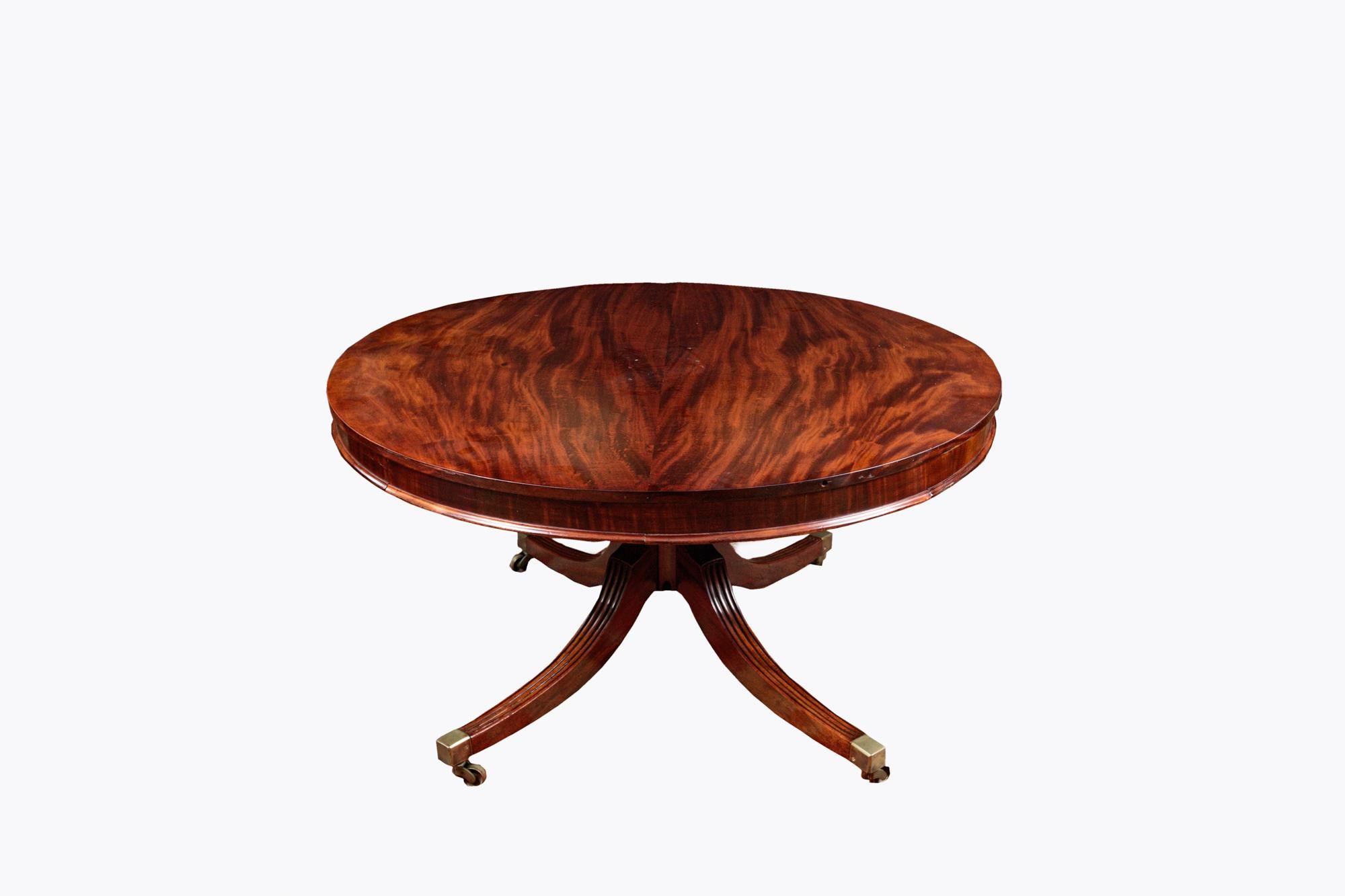 19th Century Jupe circular extending mahogany dining table retaining the original quarter round extending leaves allowing it to expand in diameter. The top supported by a turned baluster column with four reeded, hipped splay legs terminating in the