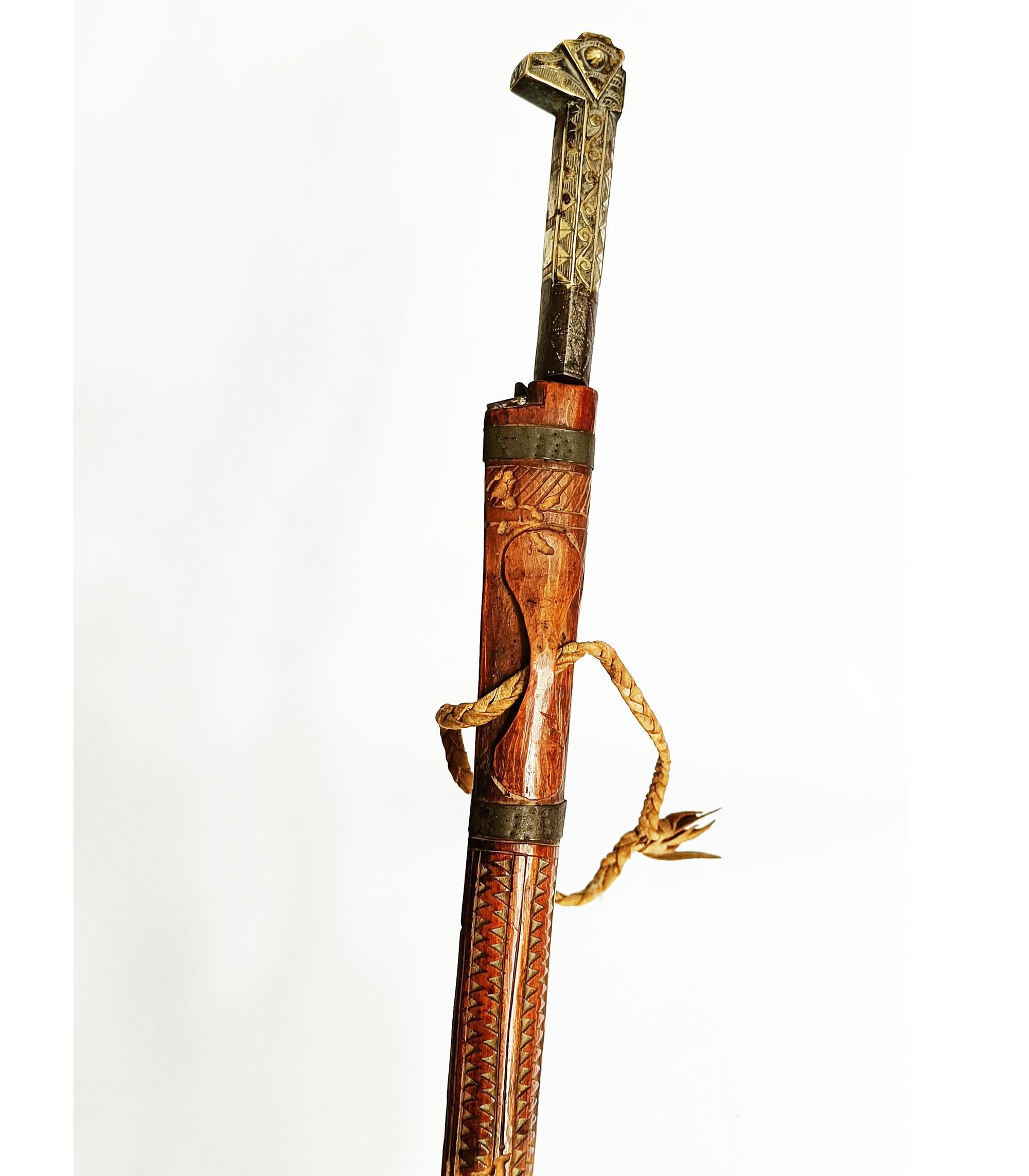  
 19th Century Kabyle Flyssa Sword – Algeria
A finely crafted long-bladed Flyssa sword from northern Algeria, traditional to the Kabyle Iflissen-im-Bahr tribe. This example features a needle-like steel blade with brass inlay, incised scrollwork,