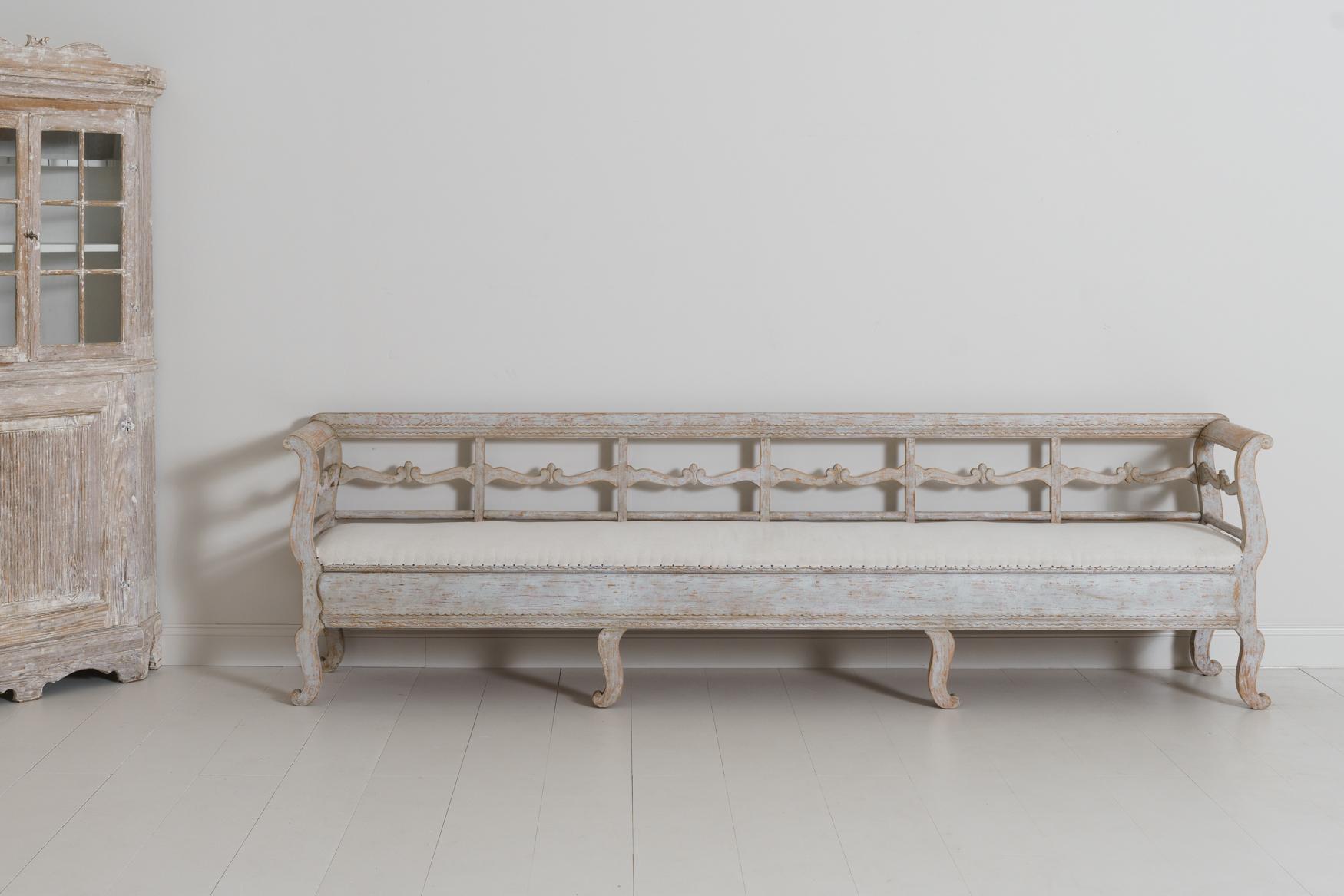 A very long sofa bench from the Karl Johan period in original paint with a newly upholstered seat.