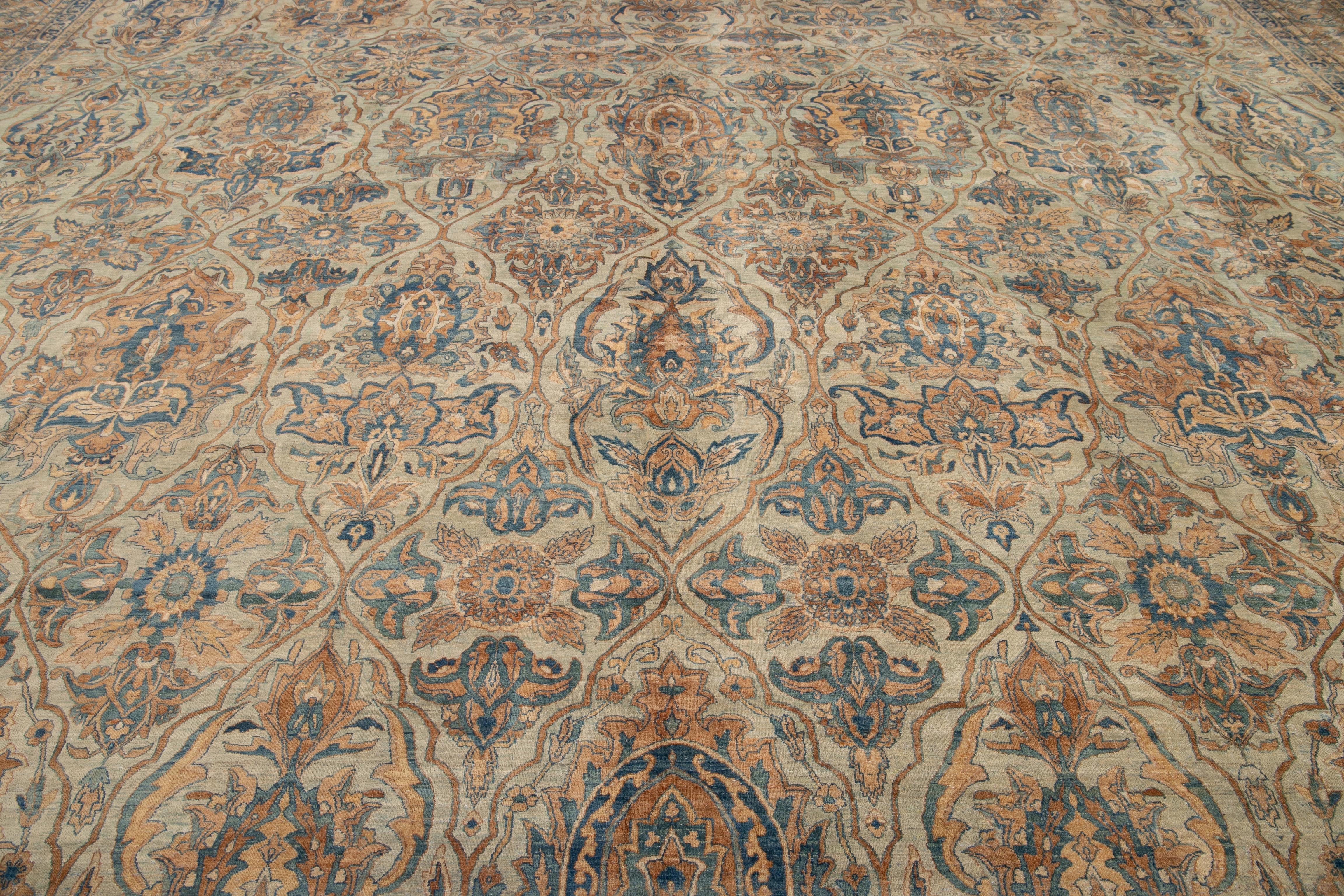 Schöner antiker handgeknüpfter Wollteppich aus Kerman in Übergröße mit hellblauem Feld. Dieser Kerman-Teppich hat einen beigen Rahmen und Akzente in einem floralen Medaillon-Muster. 

Dieser Teppich misst: 16'9
