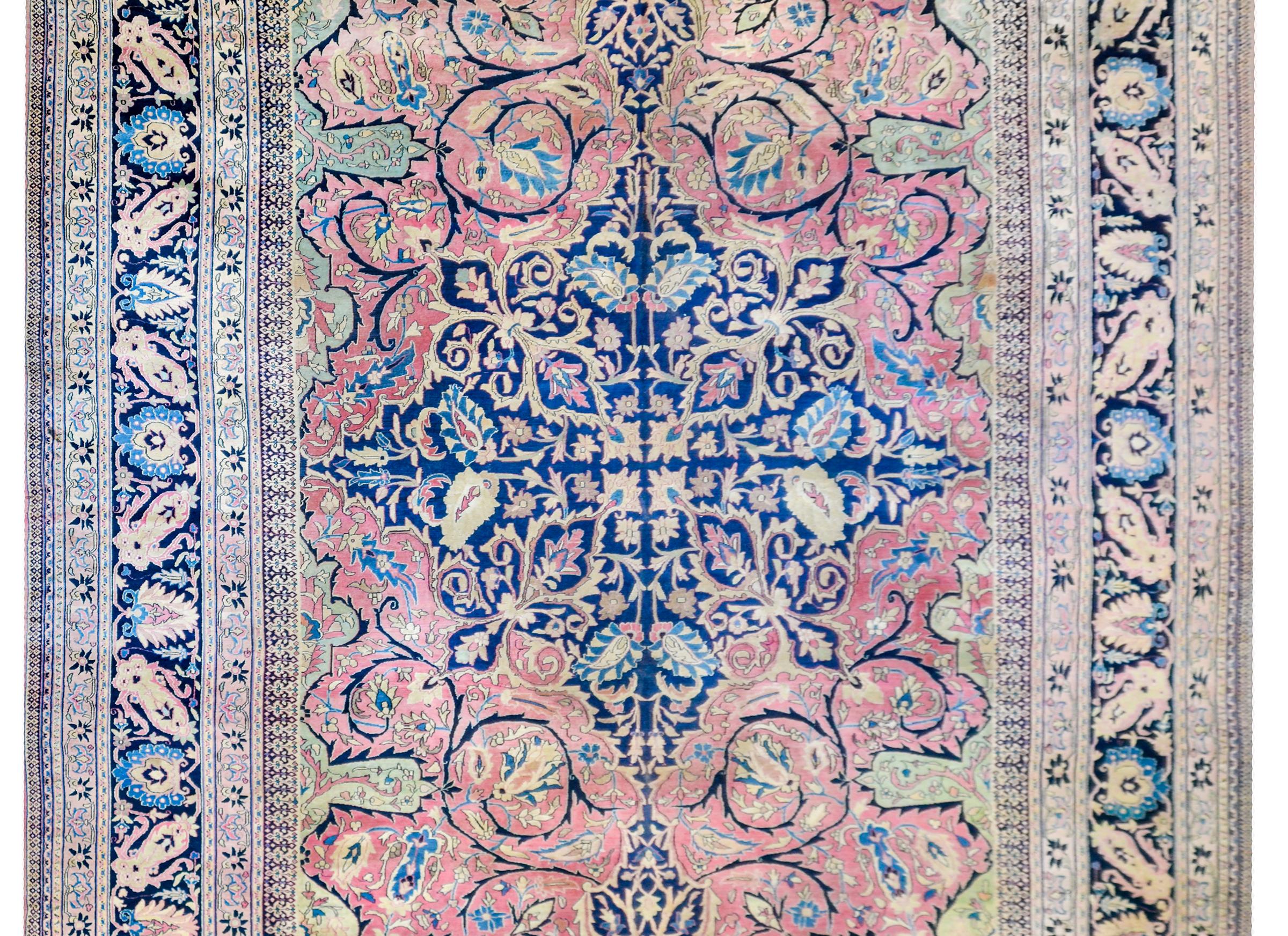 An unbelievable late 19th century Persian Khorasan Dorokhst rug with a four part mirrored pattern containing a central diamond medallion with a floral and leaf motif, on a pale cranberry background with a similar motif. The border is complex with a