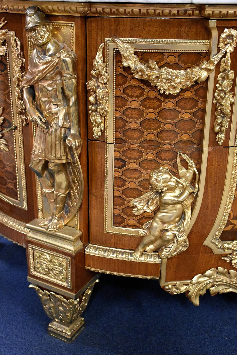 A most outstanding exhibition quality two-door, two drawer, commode having the finest detailed ormolu depicting cherubs, cornucopia, classical maidens and King Louis sunburst mount. The kingwood commode having the finest floral marquetry inlay and