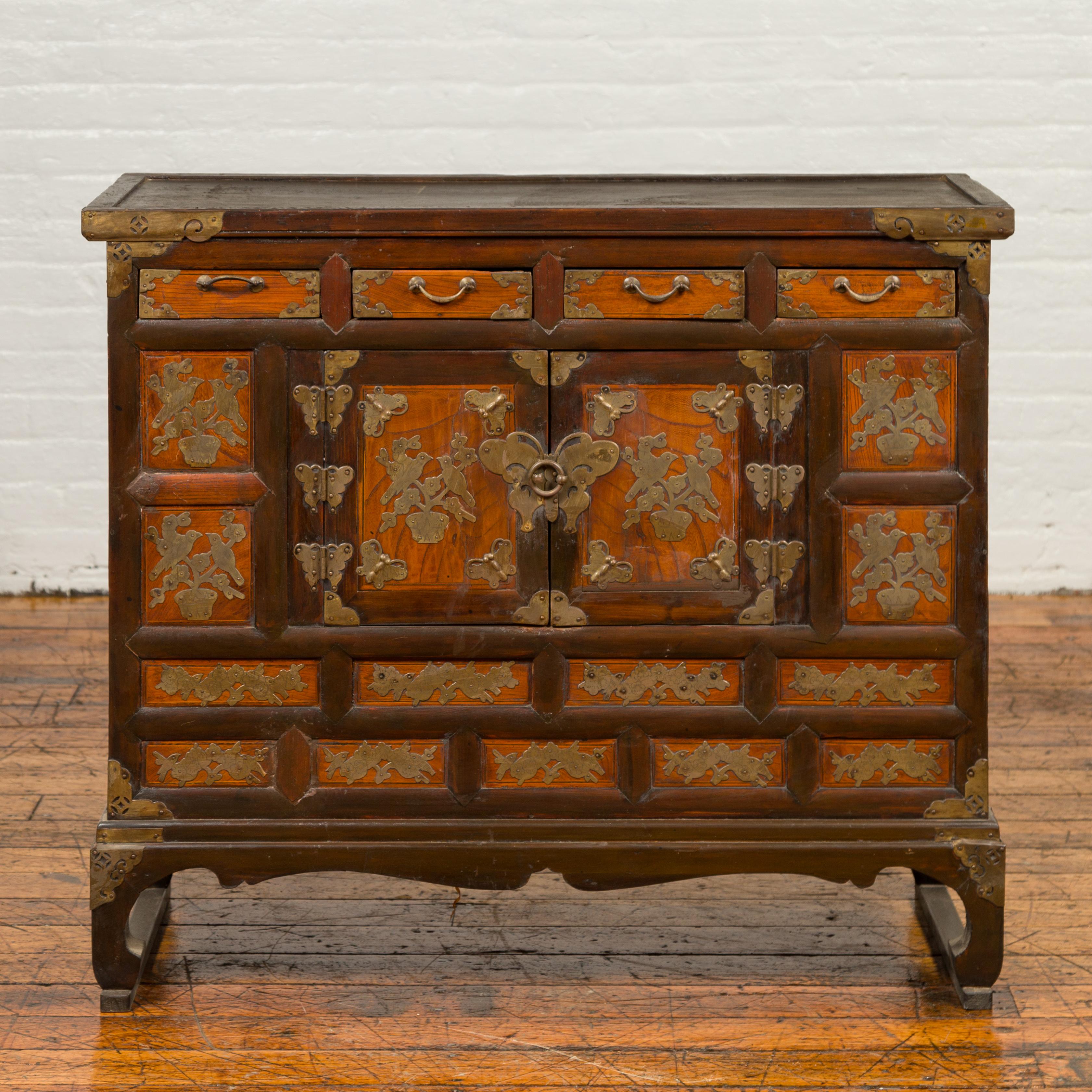 An antique Korean side chest from the 19th century, with four drawers, double doors and brass butterfly hardware. Born in Korea during the 19th century, this side chest features a rectangular top with slightly recessed central panel, sitting above a
