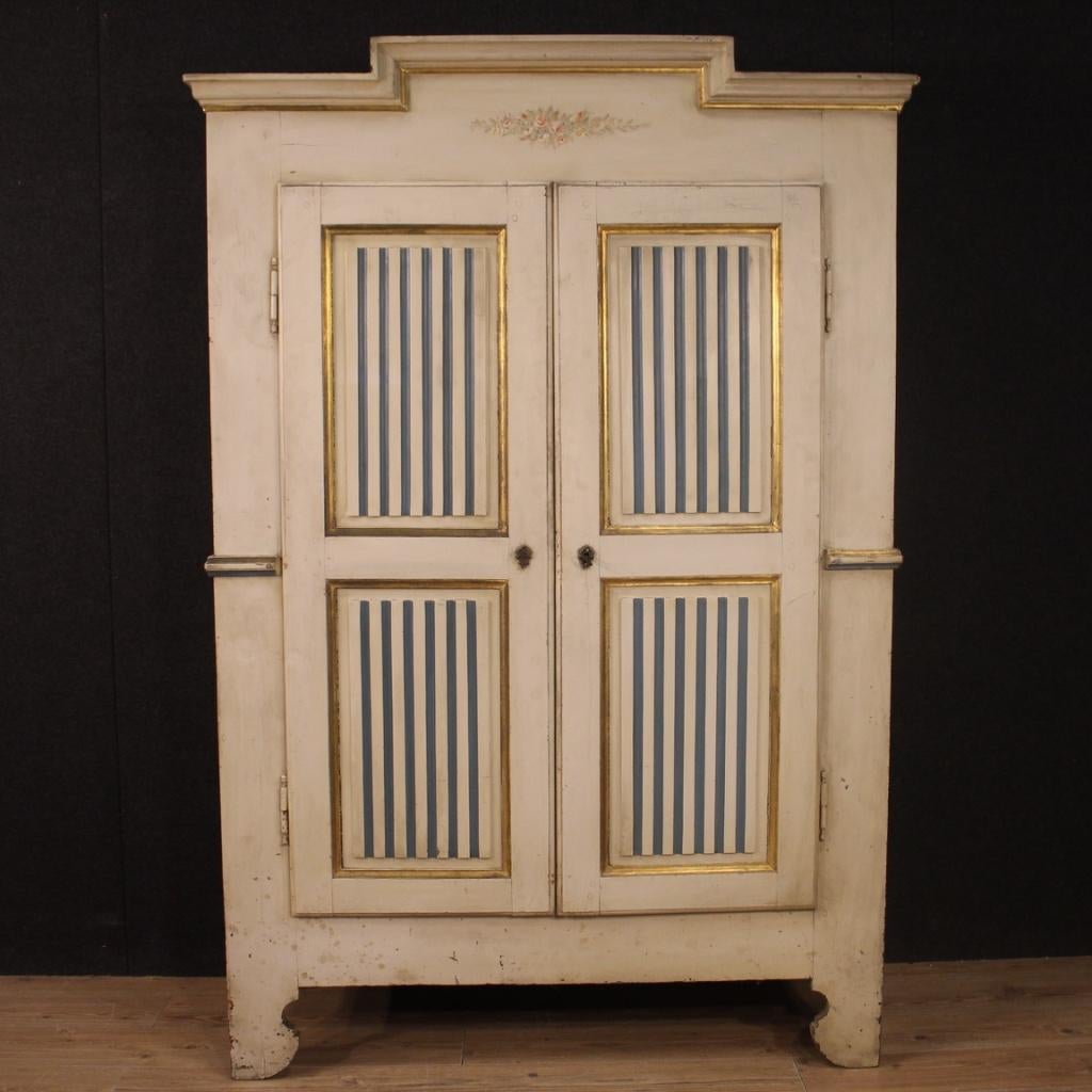Antique Italian wardrobe from 19th century. Two-doors cabinet of excellent capacity and service, lacquered and gilded in Louis XVI style. Wardrobe built in two separable bodies to facilitate transport and placement in the house. Non-original