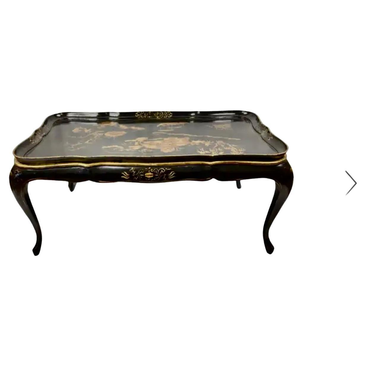 19th Century English Chinoiserie lacquered coffee table with hand painted floral design. Top features a hand-painted Chinese landscape and water scene in gold on a black background. Wooden apron has gold floral design. Cabriole legs are are black