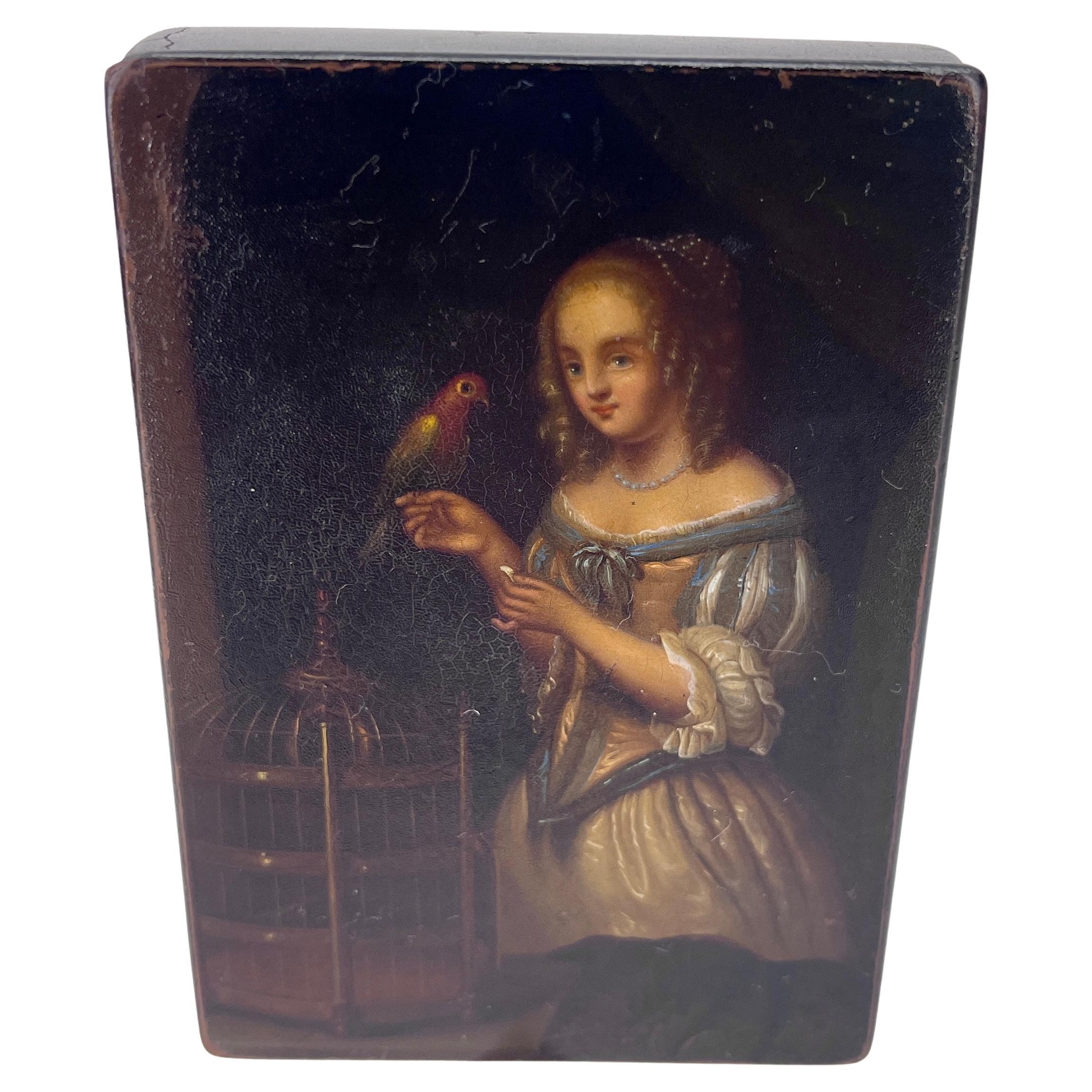 Early 19th century hand painted black lacquered Papier-Mâché snuff box or vanity box
Crafted in Austria in the early 1800's, the decorative box features a hand painted scene of a young beauty holding a parrot in the romantic Rococo manner of
