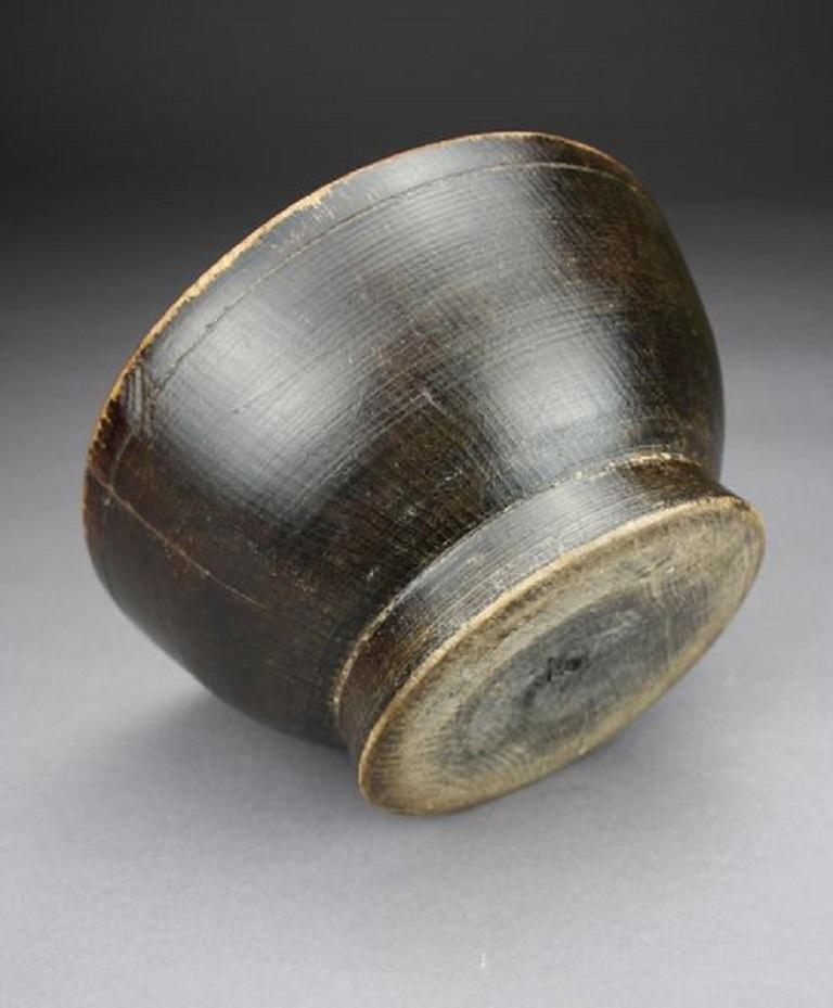 A lathe turned wood and lacquered rice bowl with pleasing patina, probably dating from the 19th century.