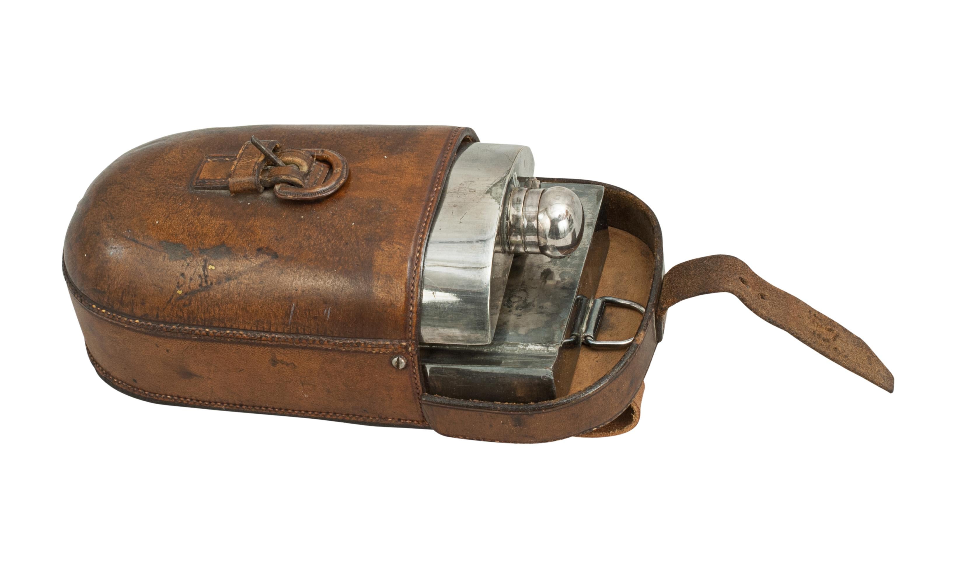 A rare ladies hunting, side-saddle, combined sandwich case and flask in leather case. The 'piggy back' hunt canteen differs from the normal style of side by side as the flask sits on top of the sandwich box instead. The leather with saddle straps