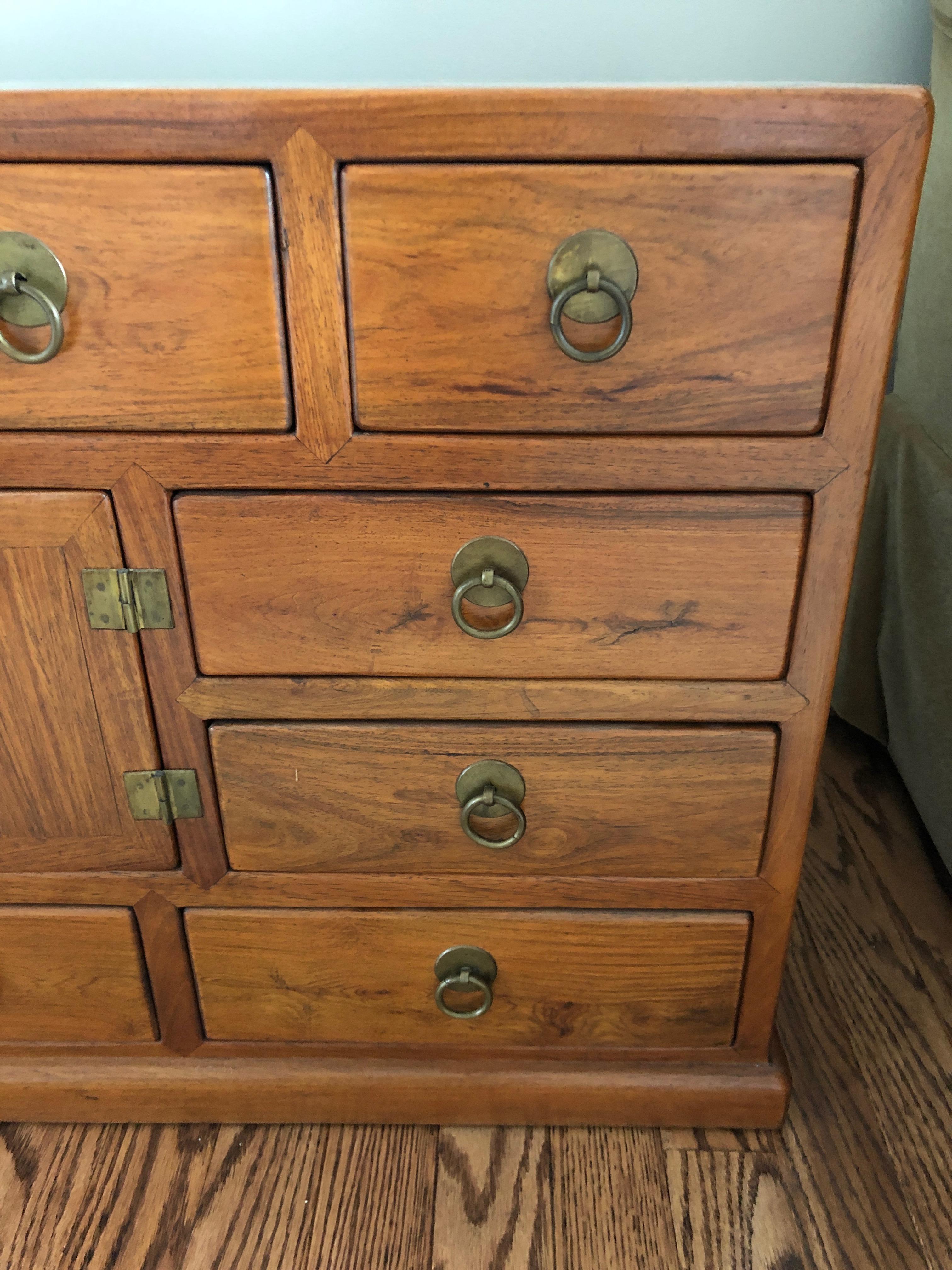 Beautiful antique apothecary or medicine chest traditionally used to store household medicinal herbs. The rectangular low chest has a variety of different sized drawers, original brass handles, two swing side handles and a molded base. Makes a