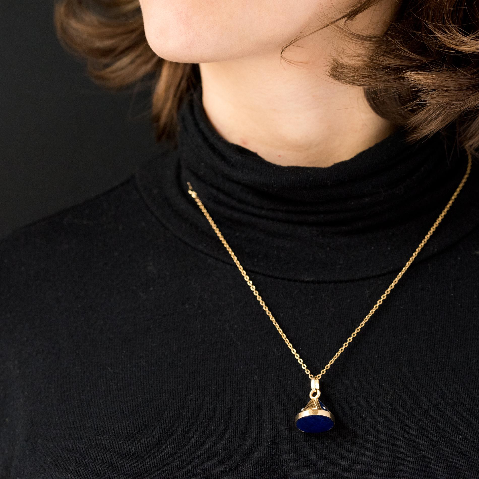 Pendant in 18 karats yellow gold, mercury head hallmark.
Antique jewel in perfect condition, it has the shape of a solid cone set at the base of a lapis lazuli disk. It is dressed with six triangular decorations alternating carvings and lapis