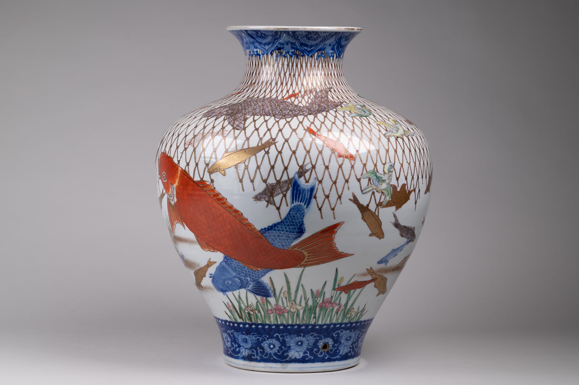 Large spectacular multicolored Imari vase. Meiji period (1868-1912) fantastical, multicolored Imari vase with very unusual subject matter of netted school of fish and flying birds above. Vase was at one point used as a lamp as there is a hole