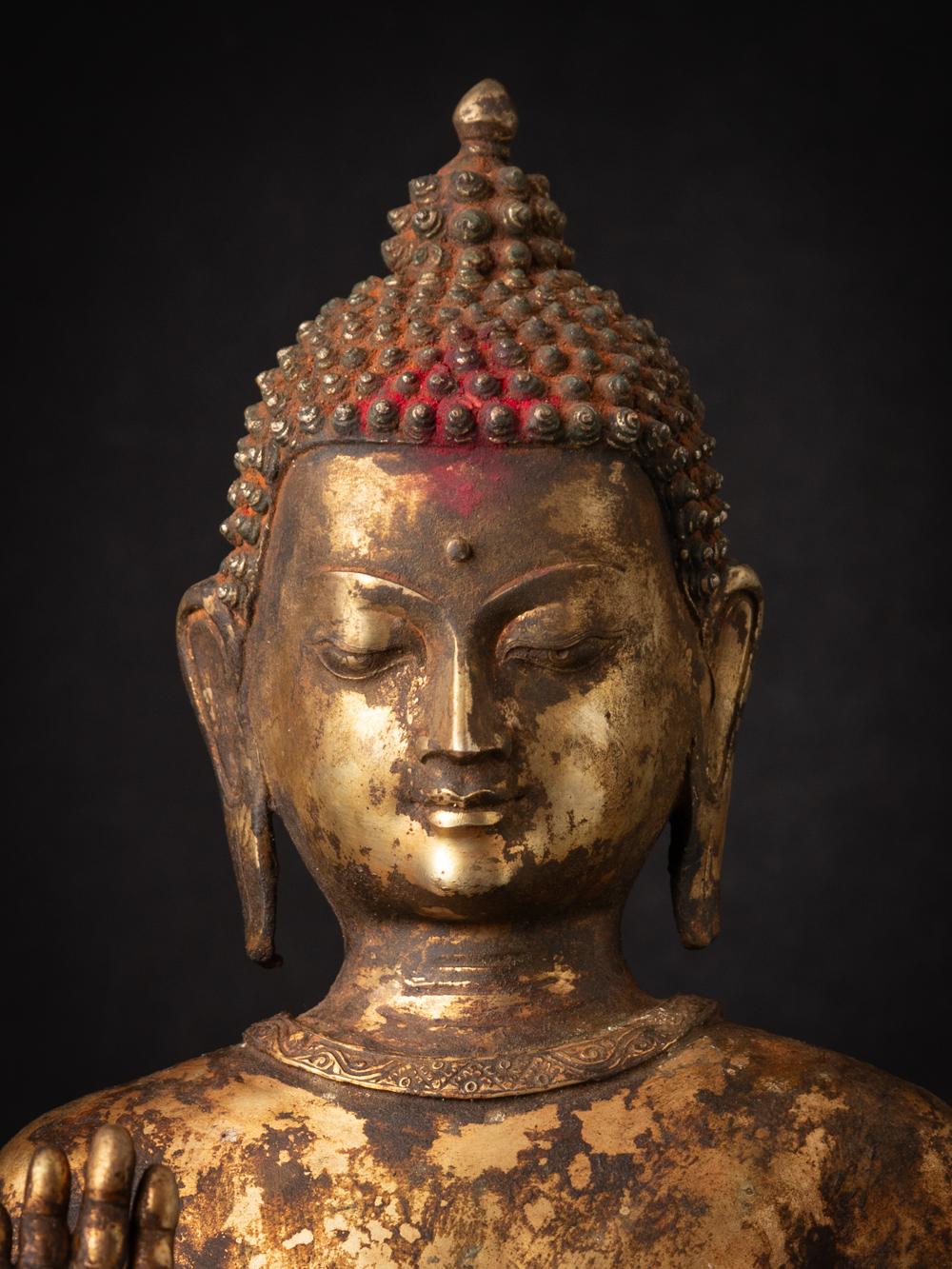 The antique bronze Nepali Buddha statue is a captivating and spiritually significant artifact originating from Nepal. Crafted from bronze and adorned with fire gilding in 24-karat gold, this statue stands at 74.5 cm in height and measures 29 cm in