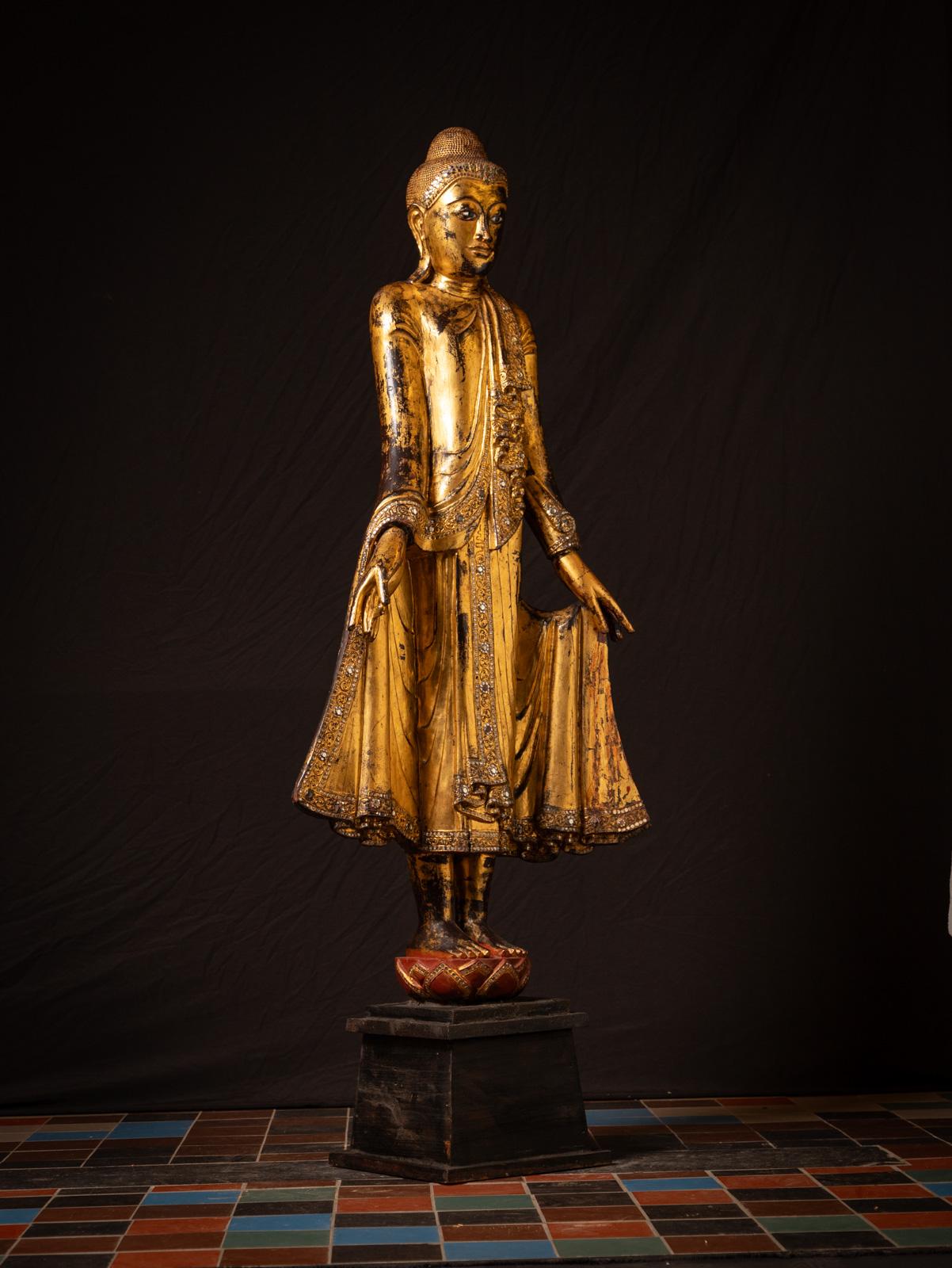 Cette grande statue de Bouddha antique en bois de Mandalay est un exemple étonnant de l'artisanat birman du XIXe siècle. Réalisée en bois et dorée à l'or fin, elle mesure 181 cm de haut, 73,5 cm de large et 35 cm de profondeur. Ses yeux