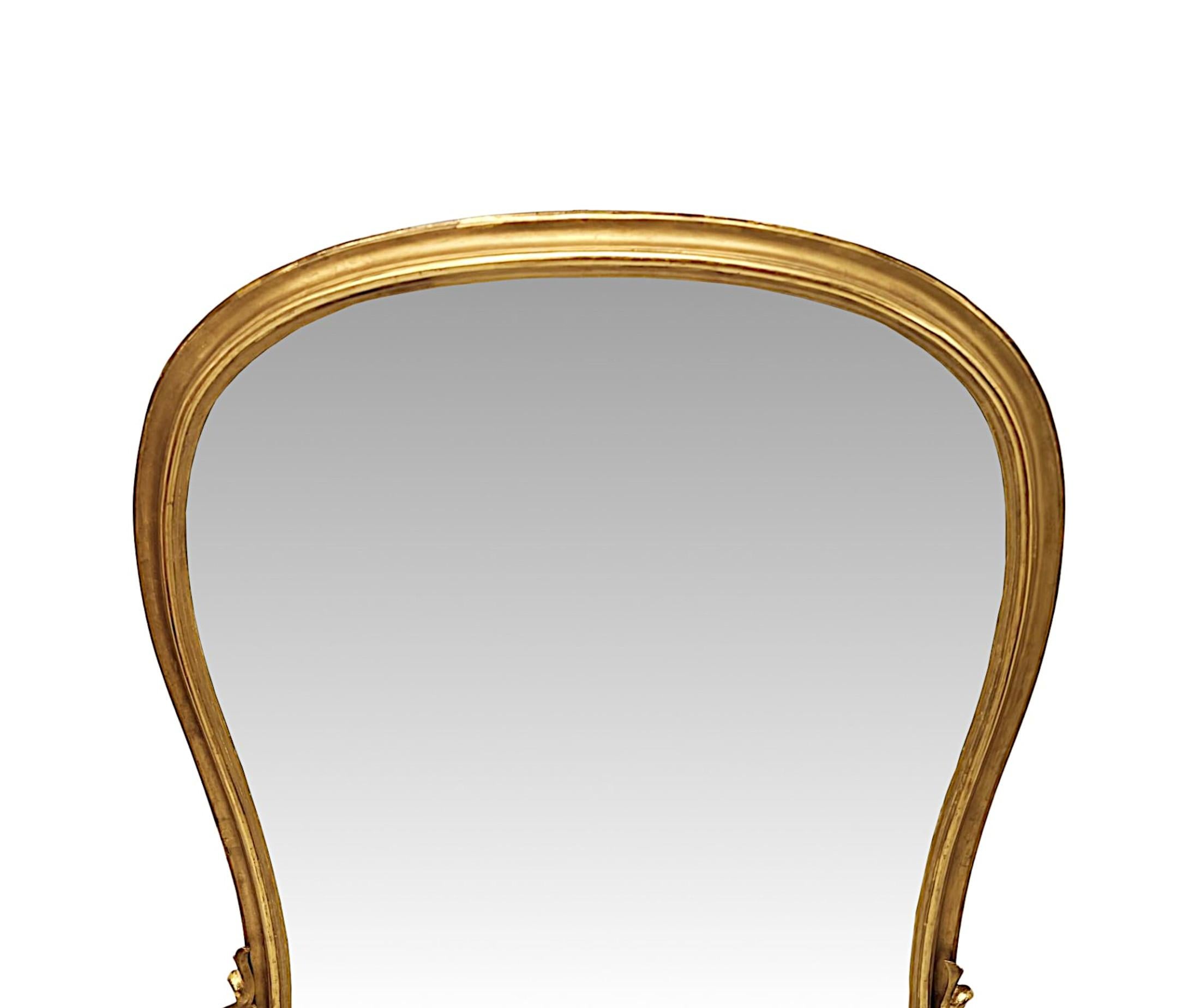 A stunning 19th Century archtop giltwood overmantel mirror of grand proportions.  The shaped and curved mirror glass plate of waisted form is set within an finely hand carved moulded, fluted and elegantly simple giltwood frame, supported on shaped