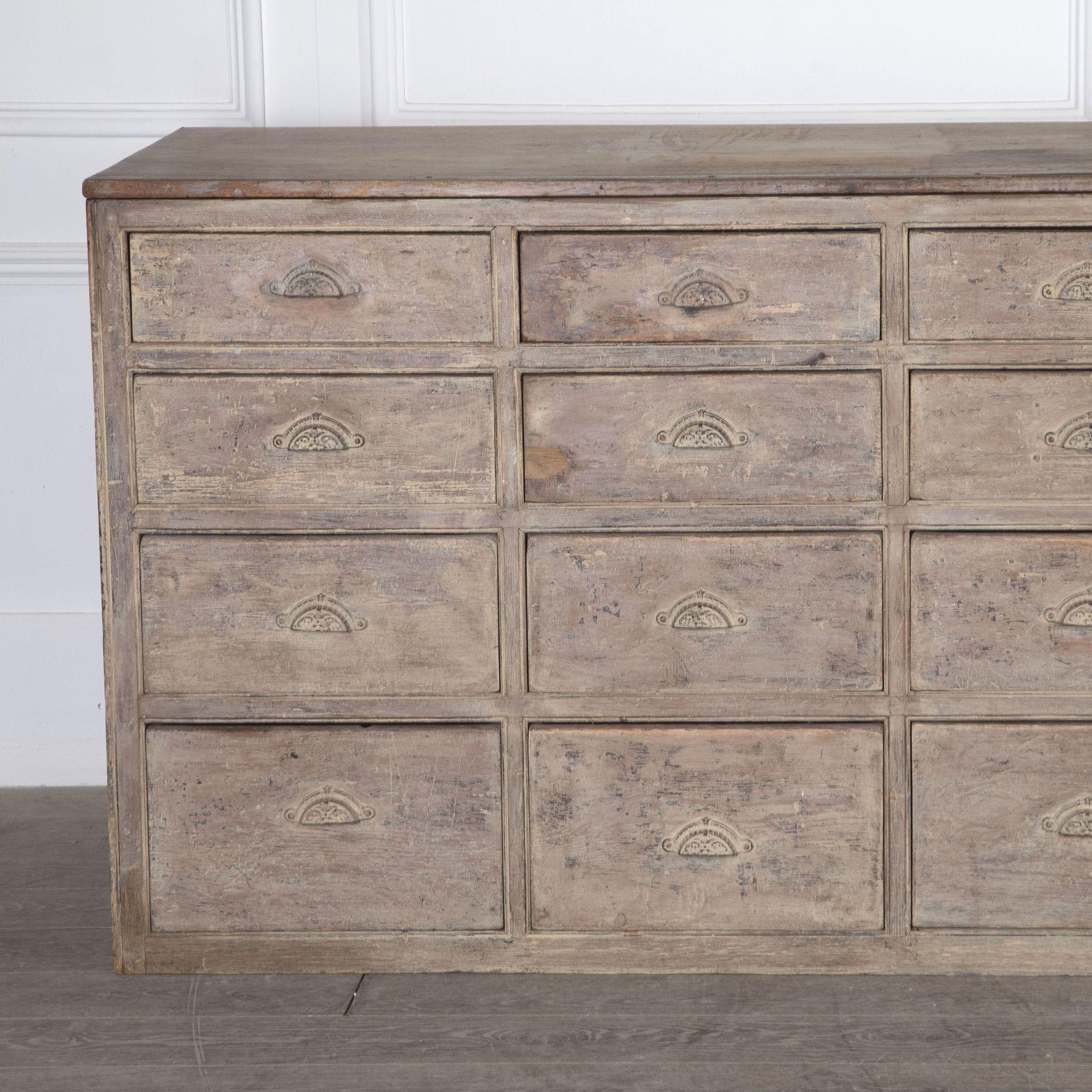 Late 19th Century bank of drawers in two bays, each bay comprising four columns of four drawers each.
The second row of drawers from the base run on small metal roller wheels fitted to the drawer runner rails.
There is a circular mark to the top at