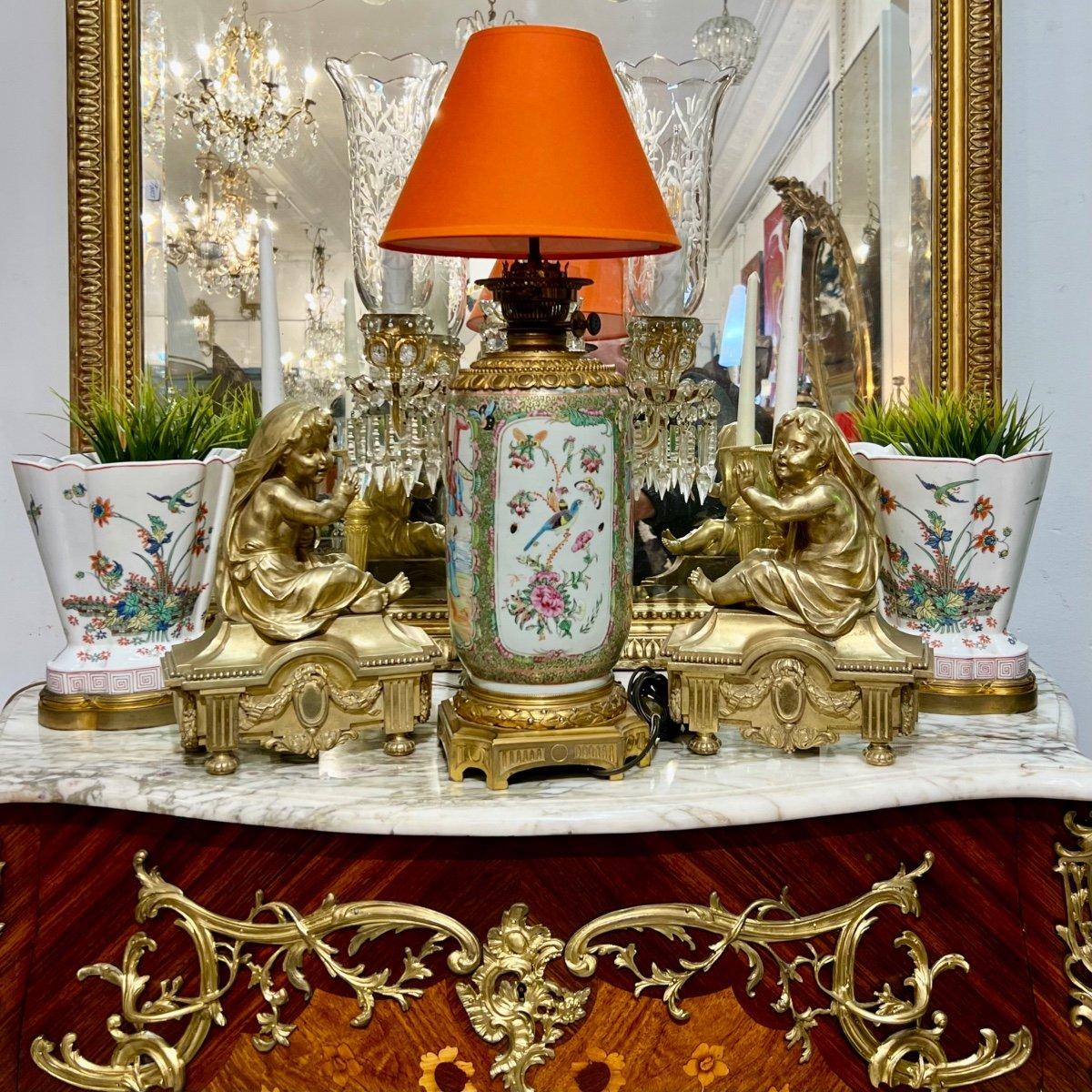 We present you with this impressively sized Cantonese porcelain lamp in a cylindrical shape, dating back to the Napoleon III era. It features prominent images depicting scenes from the imperial Chinese palace life within its cartouche. It is further