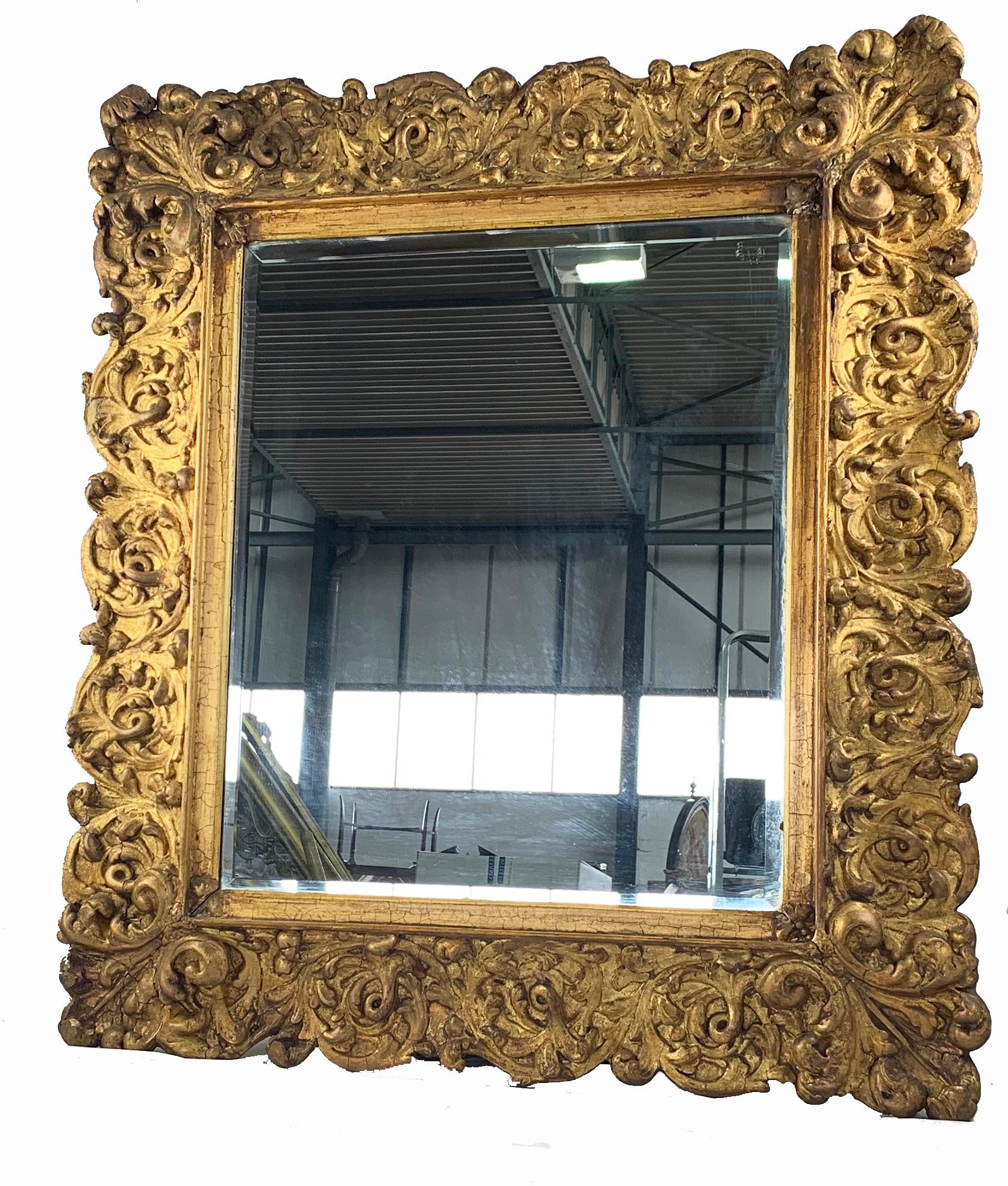 An Impressive Carved Gilt wood mirror of large proportions. Probably Italian late 19th century. Of rectangular form ornately carved with scrolling foliage and leafage.