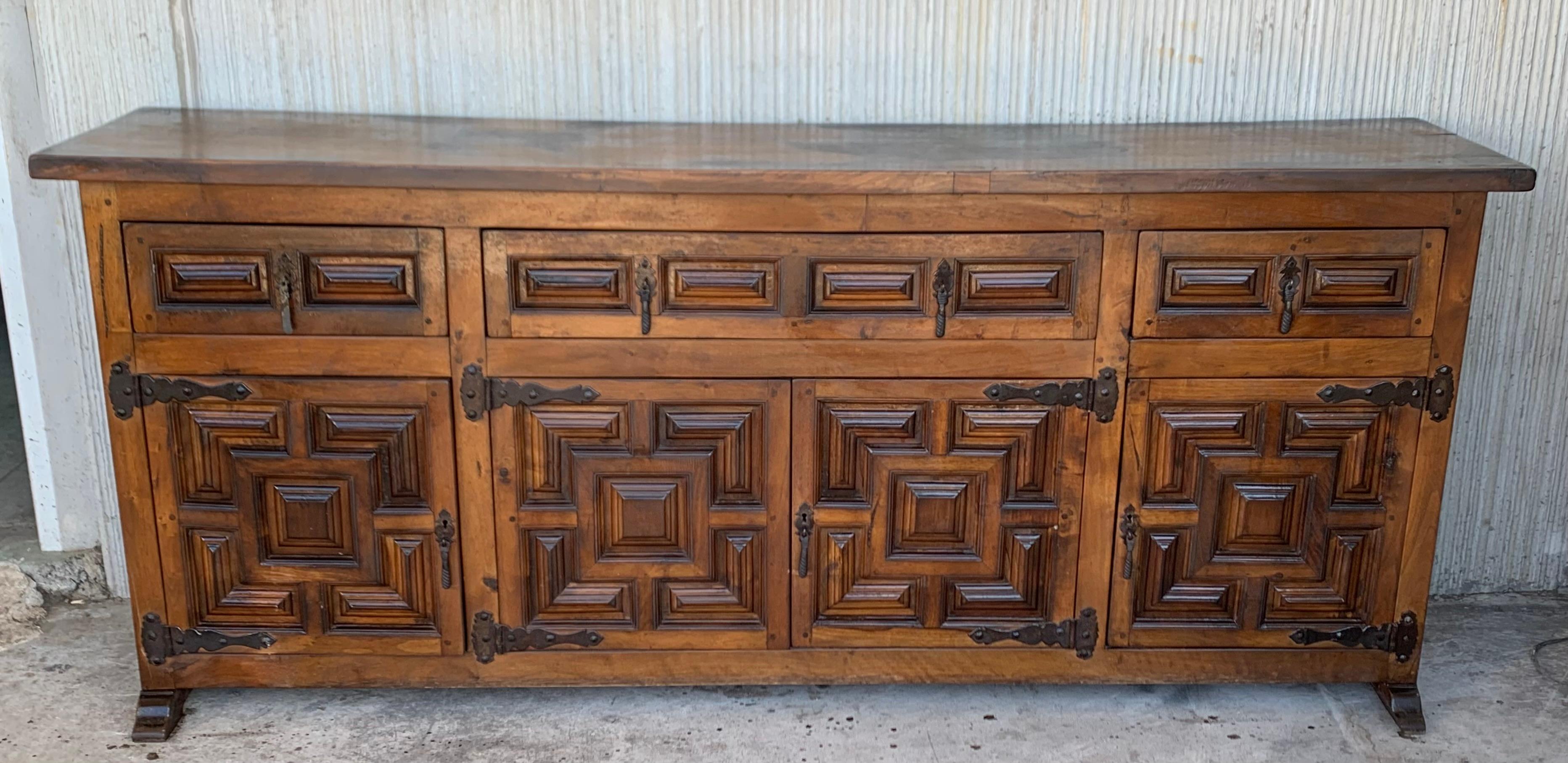 From Northern Spain, constructed of solid oak, the rectangular top with molded edge atop a conforming case housing three drawers over four doors, the doors paneled with solid walnut, raised on a plinth base.
Very heavy and original cabinet.
    