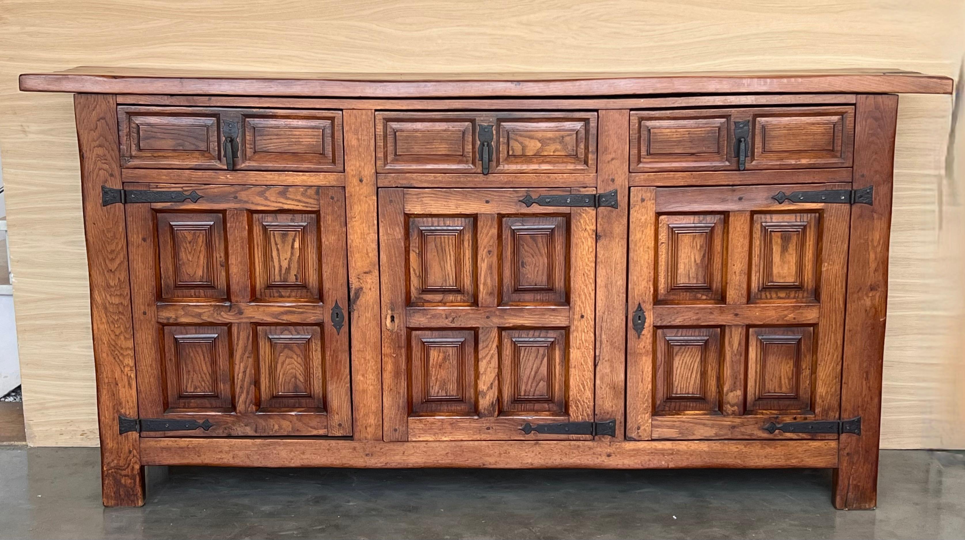 Procedente del norte de España, construido en roble macizo, la parte superior rectangular con borde moldurado sobre una caja conformada que alberga tres cajones sobre tres puertas, las puertas paneladas con nogal macizo, elevado sobre una base de