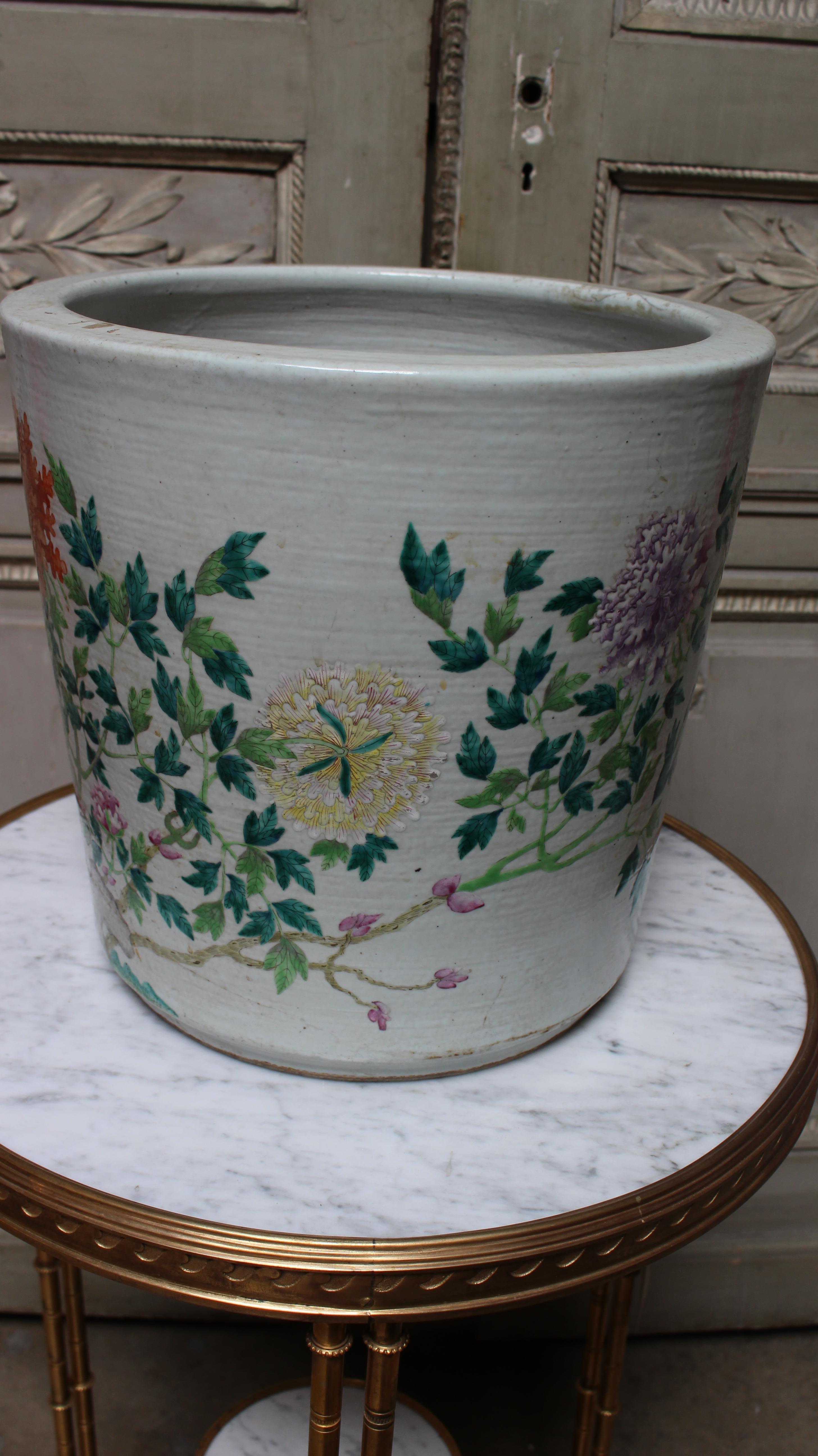 A 19th century large Famille Rose Chinese porcelain jardiniere or planter depicting a scenic landscape of chrysanthemums and other floral still life. 