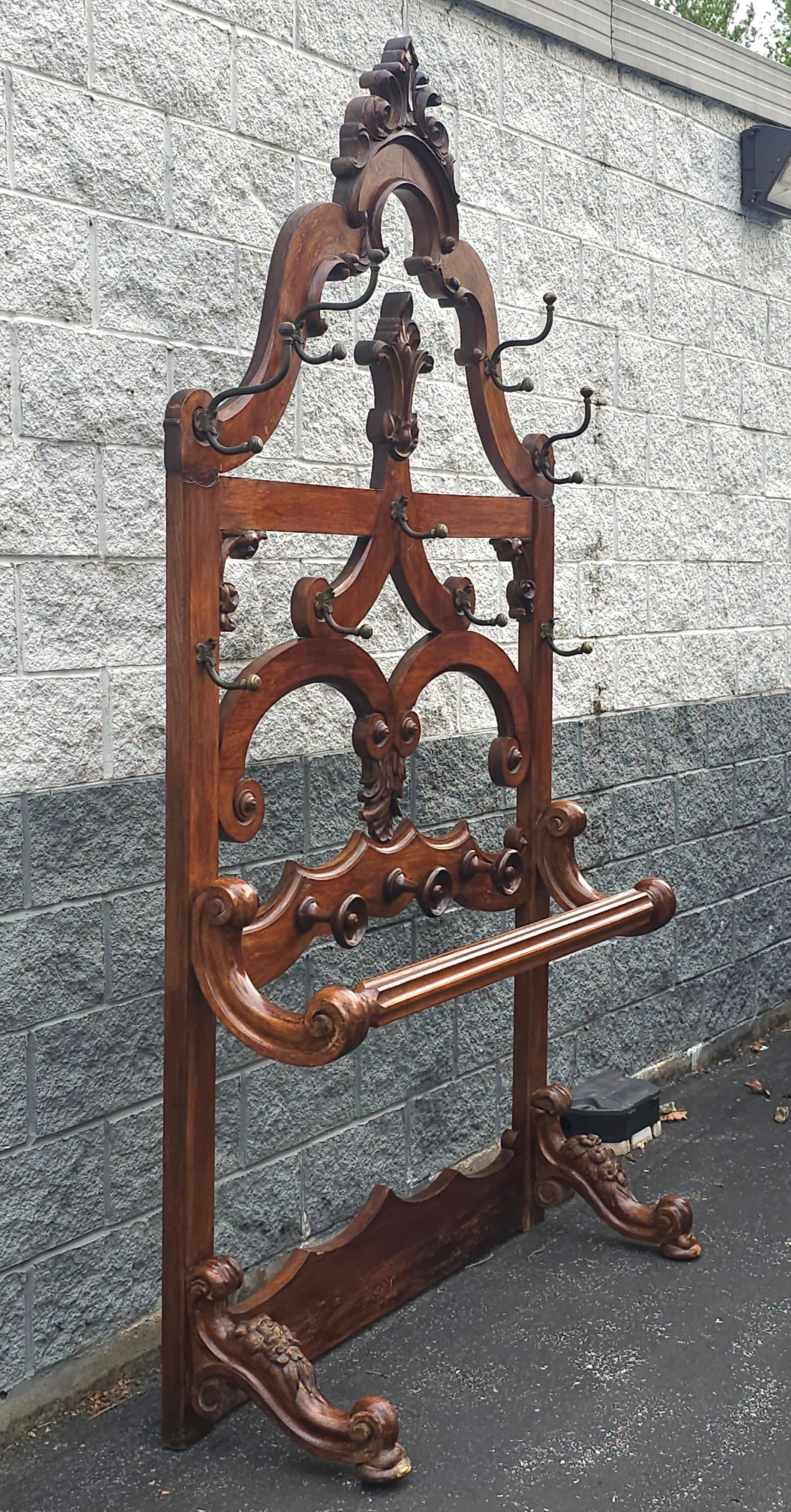 This large, 19th Century  Eastlake handcrafted Oak hall rack for coats and hats will make a statement at the entrance of your home. Come with 13 Brass hooks and 3 carved  rounds hooks. Measures 54
