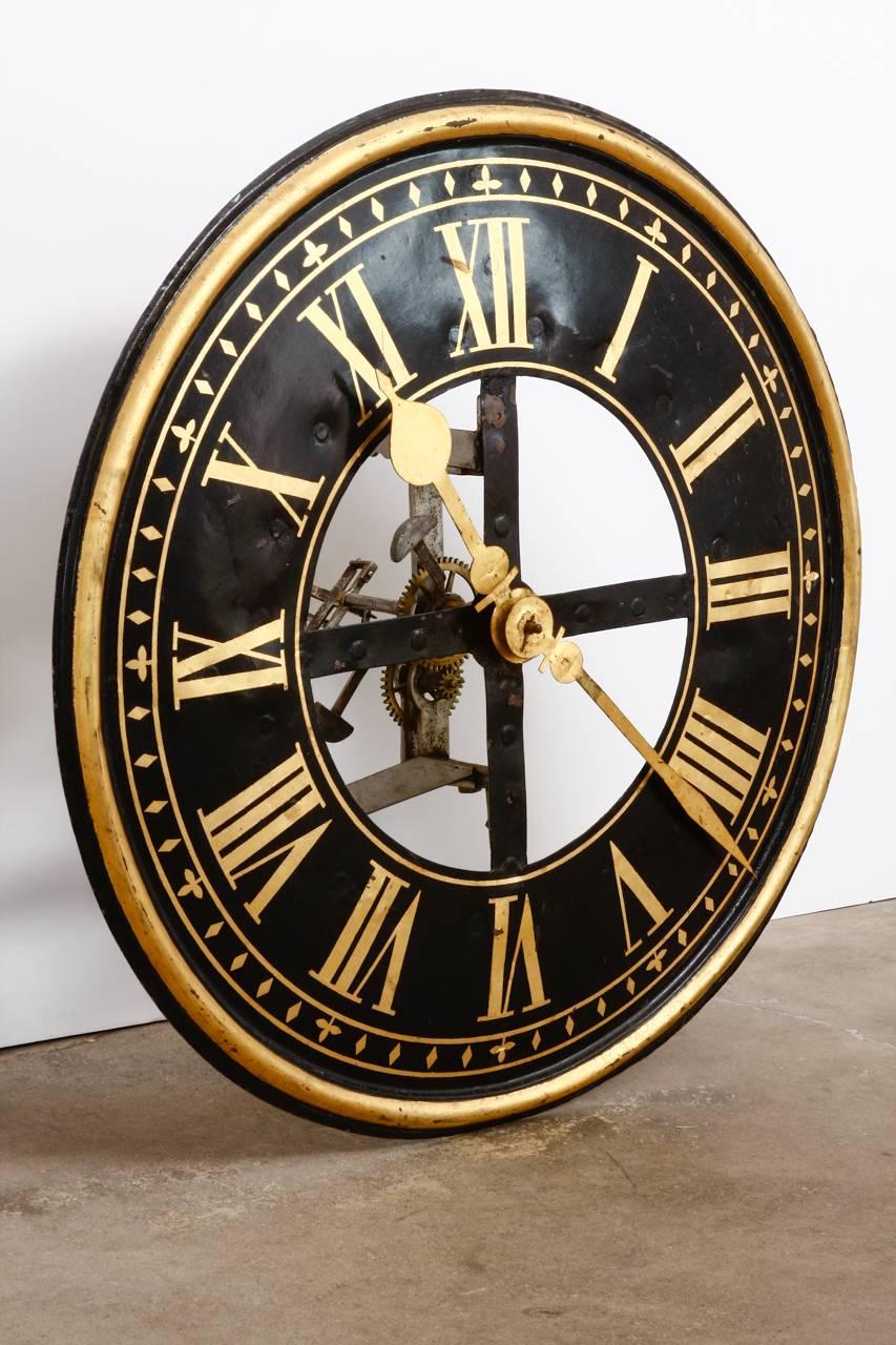 Rare 19th century English iron clock face with working gears and parts. Features a large hand-painted lacquer face with gilt trim and numerals. The clock still has its hands attached and the moving parts can be viewed through the window in the