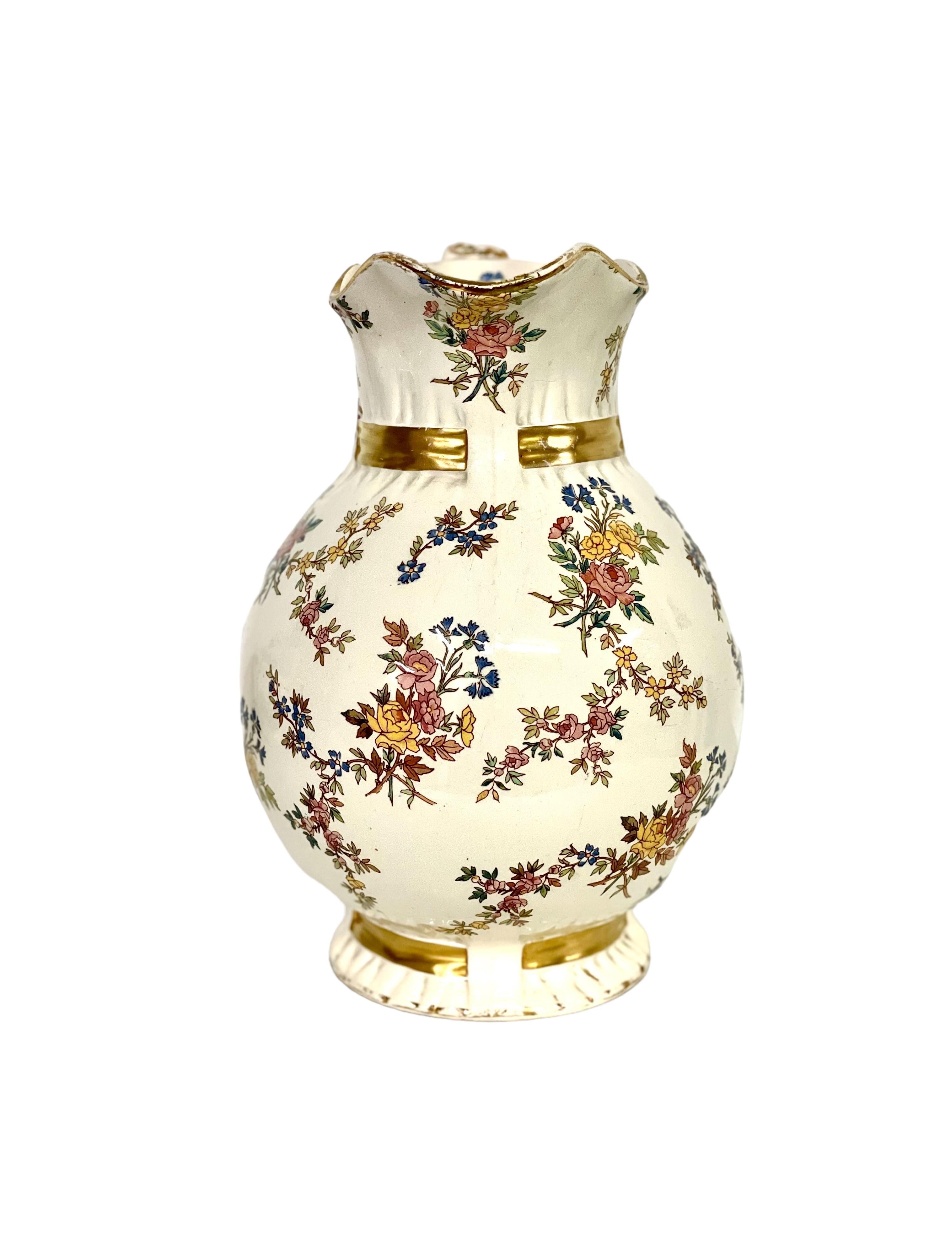 An exquisite 19th century Pitcher from the renowned earthenware manufacturer at Sarreguemines on the French/German border. Decorated in a very pretty Louis XV floral transferware motif and enhanced with bands of gilt-style faux-threaded ribbon and