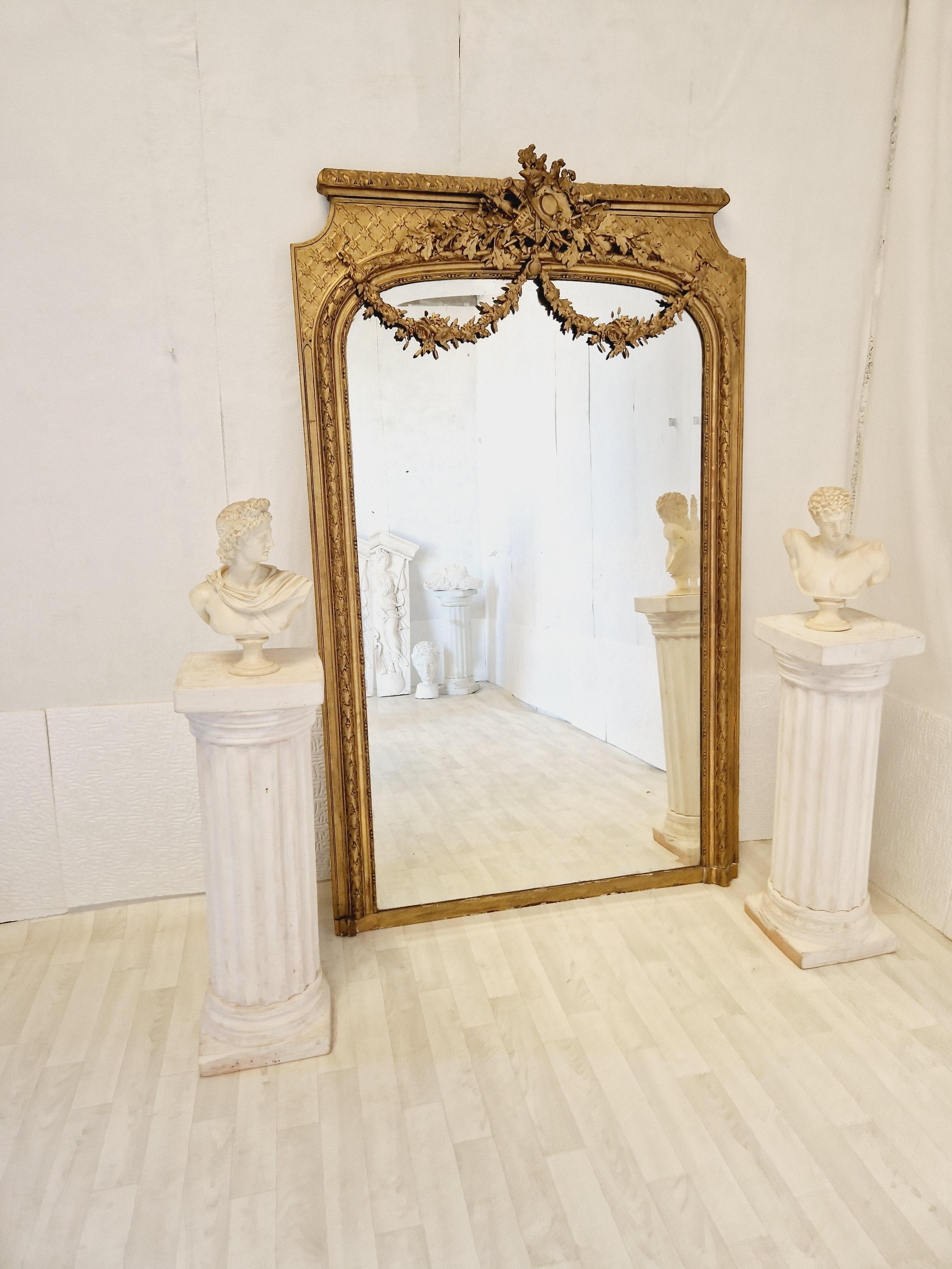 This Beautiful mirror is of the Louis XVI style and dated around 1870. The surface of the mirror has giltwood frame and the original glass mirror plate, there is a harvest theme with a straw hat upon a floral crest which is a unique feature of the