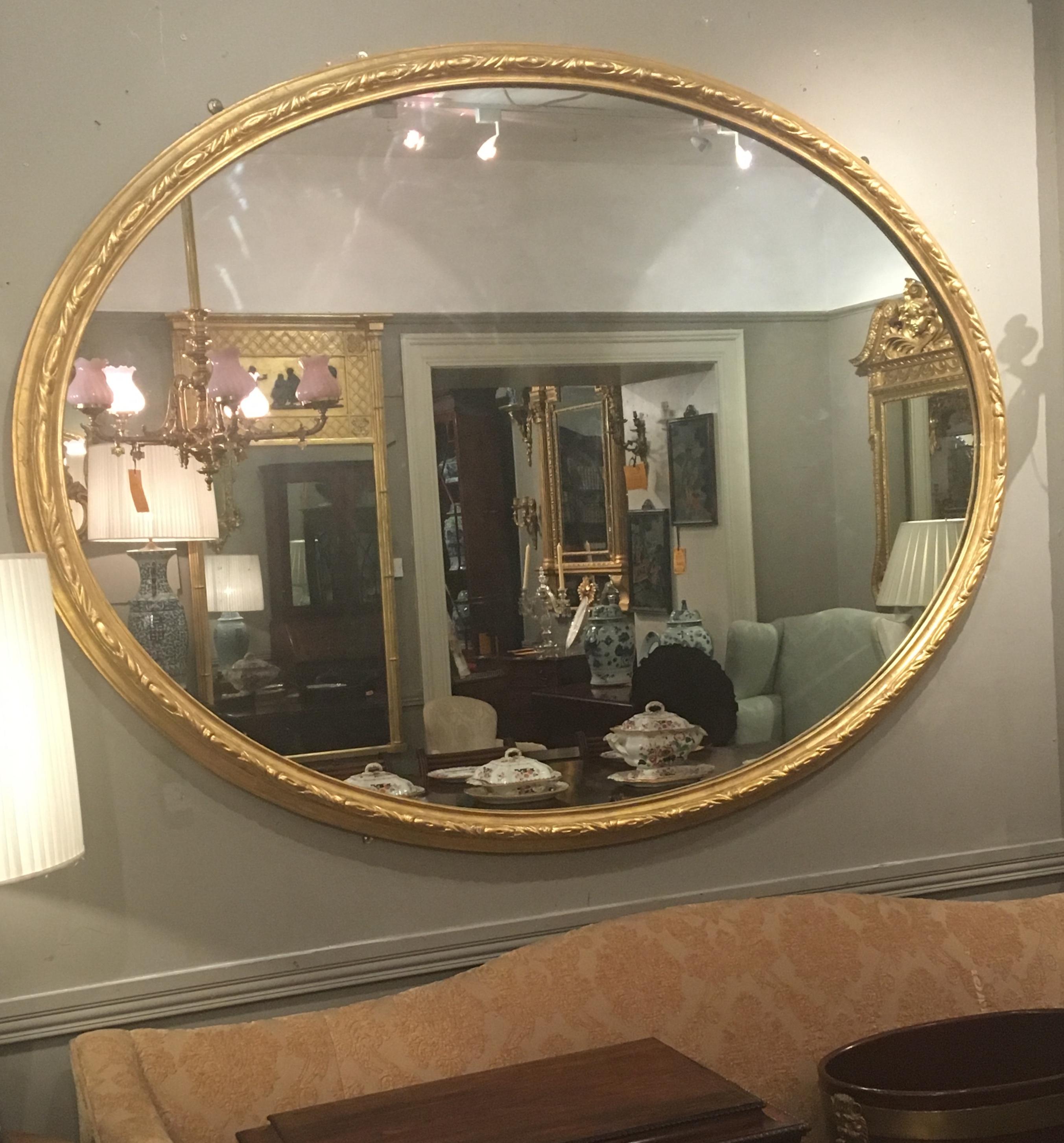 19th Century large giltwood mirror of oval form with carved ribbon and dart motif, can be hung both horizonally and vertically.