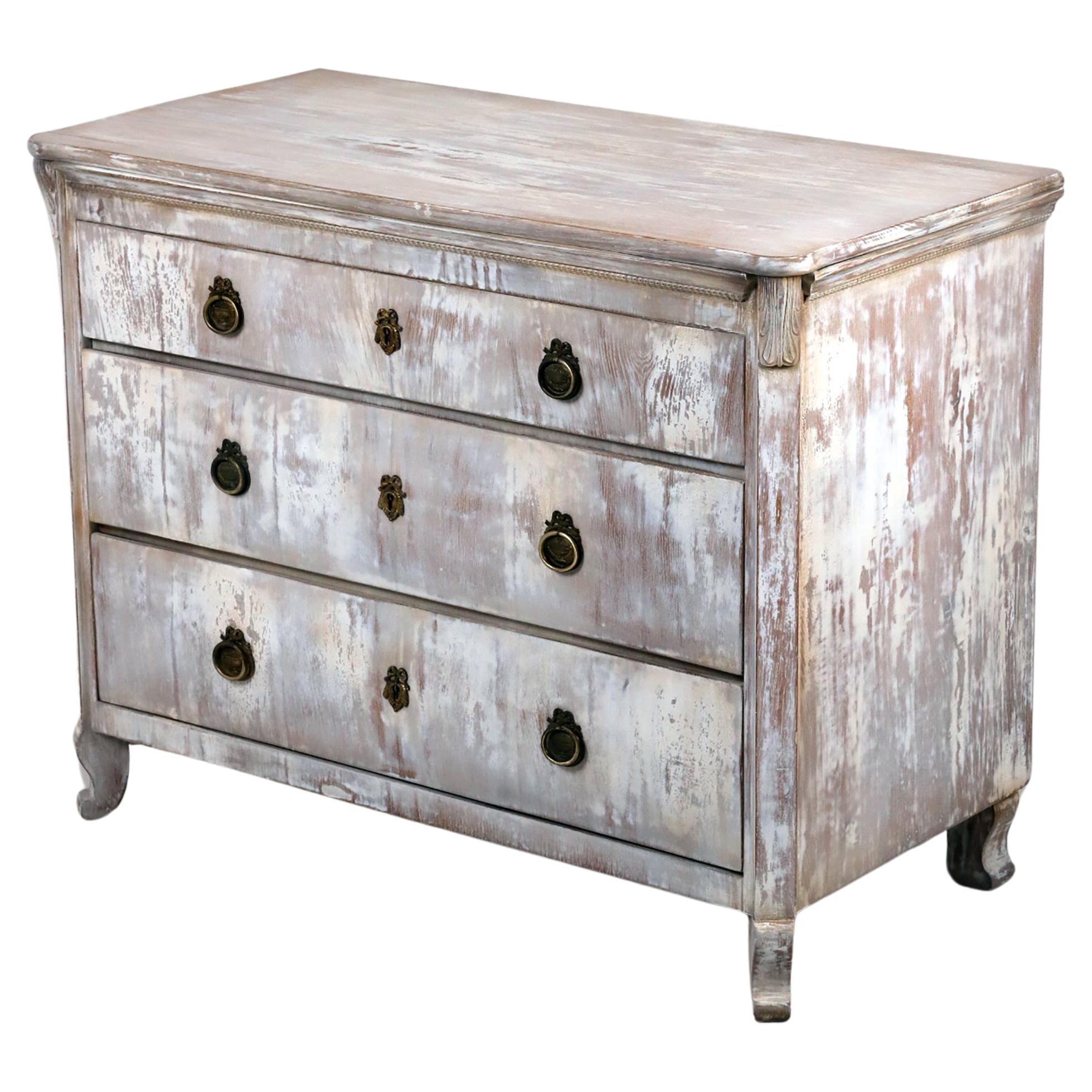 Cómoda de estilo Gustaviano del Siglo XIX, 
Alemania, 1850
Ashwood

Cómoda decorativa de estilo sueco gustaviano, de madera maciza de fresno, con tres cajones y herrajes de latón. Tres cerraduras con tres llaves. 
Bonita forma con adornos