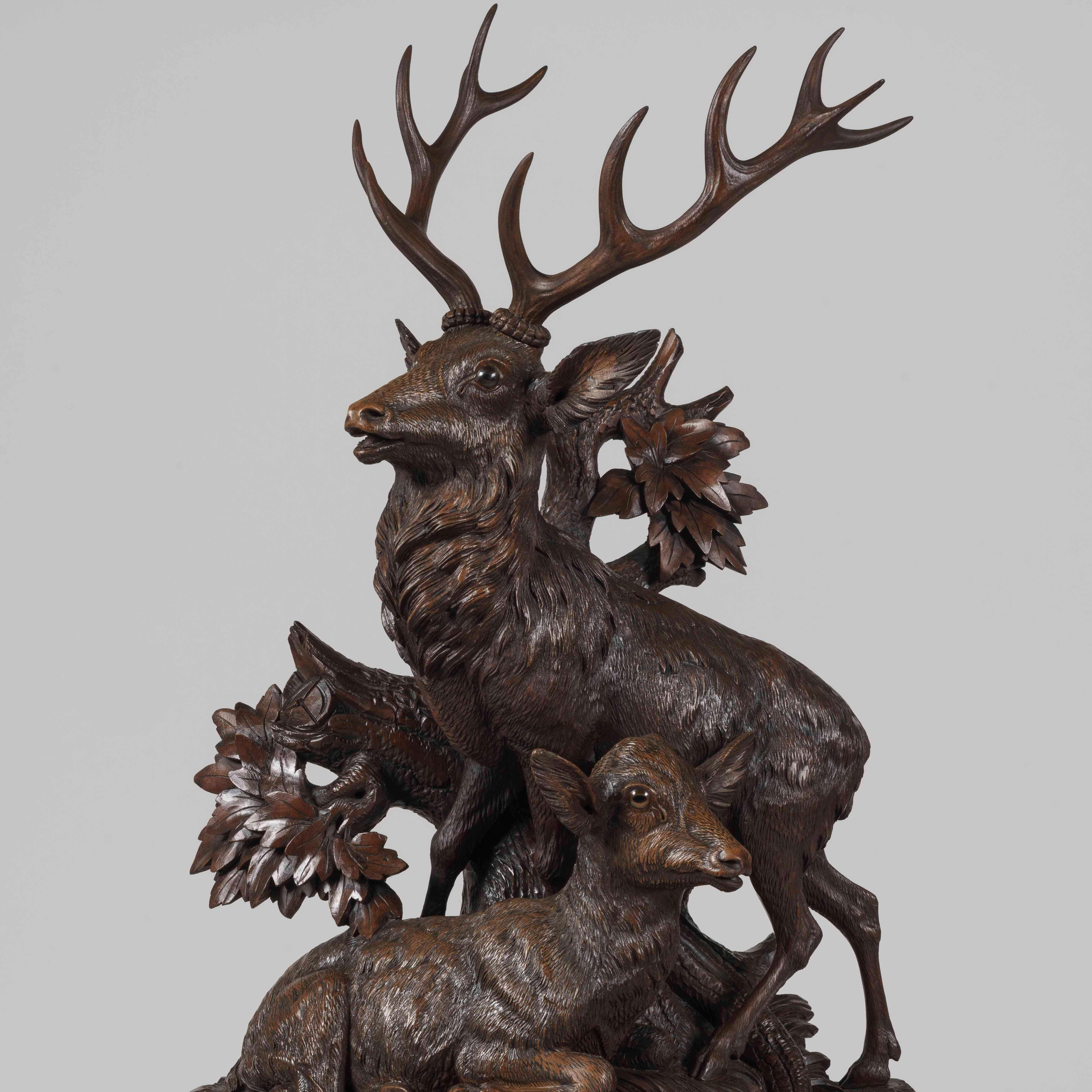 A large Black Forest mantle clock

Constructed in carved linden wood, fitted with a two train 8 day striking clock movement; mounted on a shaped branchwork base, the naturalistic ground of rockwork, tree branches, oak leaves and ferns surrounding