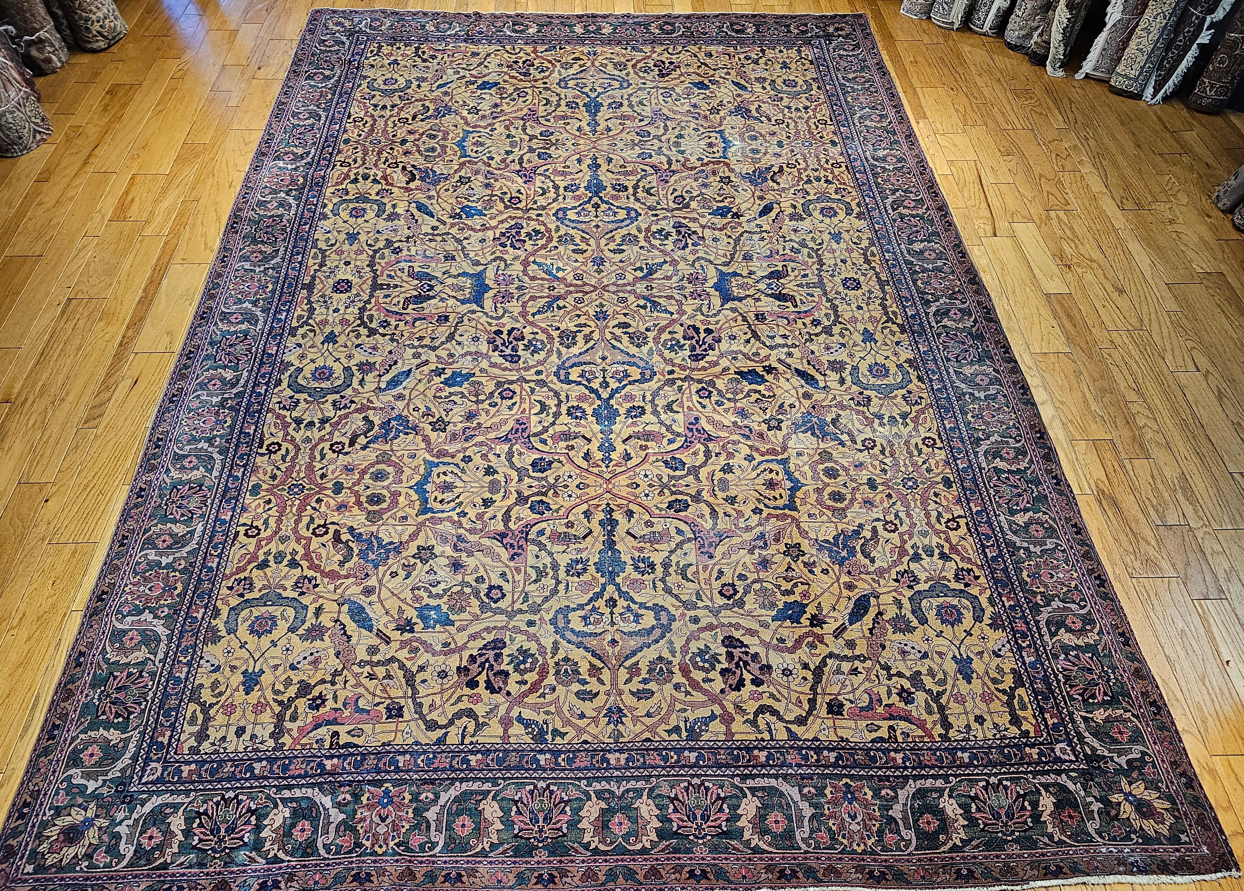 A beautiful hand-knotted Indian Agra woven in the last quarter of the 1900s in an allover garden pattern. The rug has a saffron yellow background color with designs of birds and branches in French blue, pink, red, green, brown and ivory.  The Agra