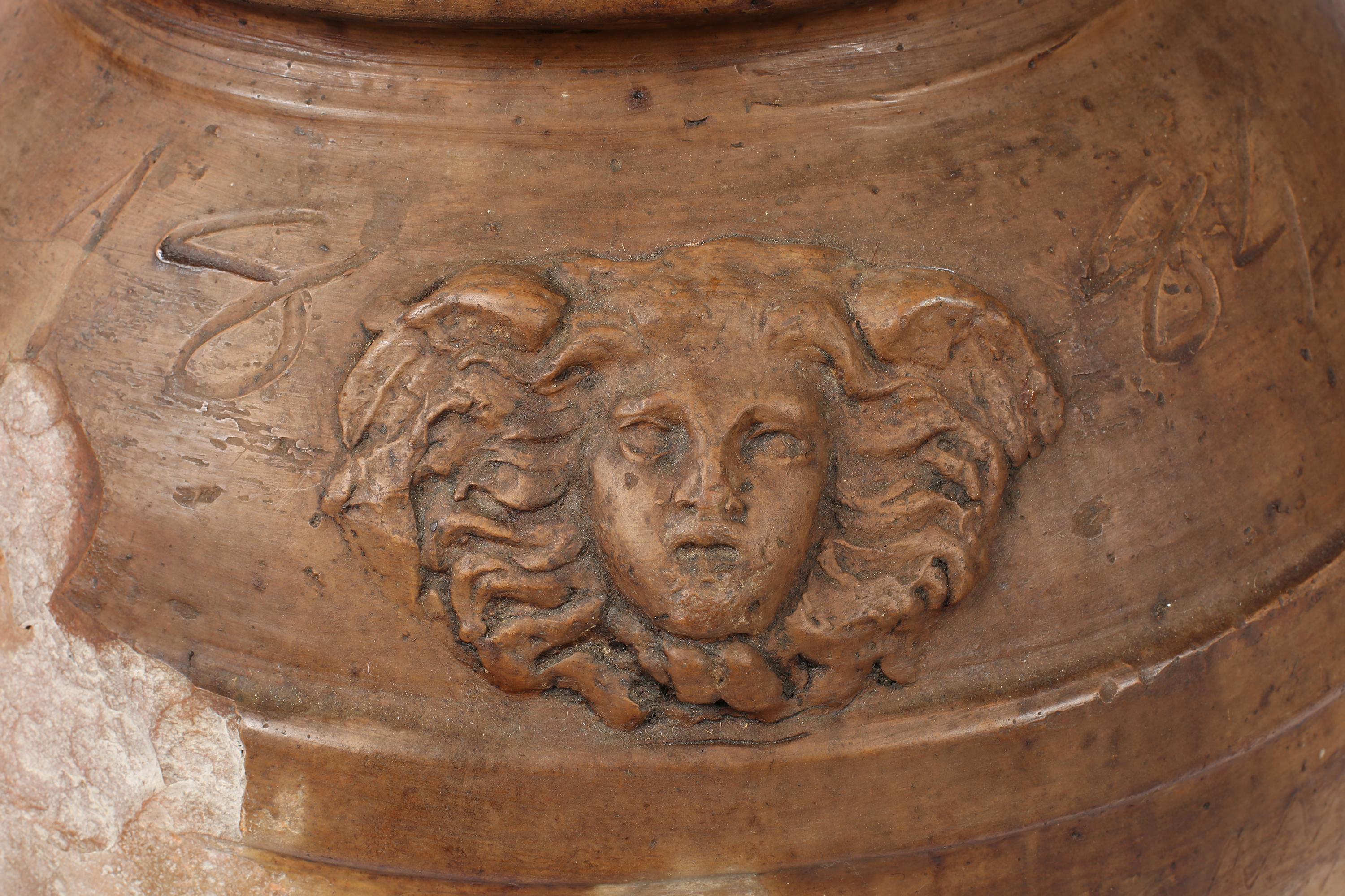 Importante jarra de terracota para vino/aceite de finales del siglo XIX, procedente de la Toscana. Muy patinado, con pérdidas de carácter por todas partes, pero conserva una máscara estilizada de Medusa y otra máscara grotesca debajo. Inscrita con